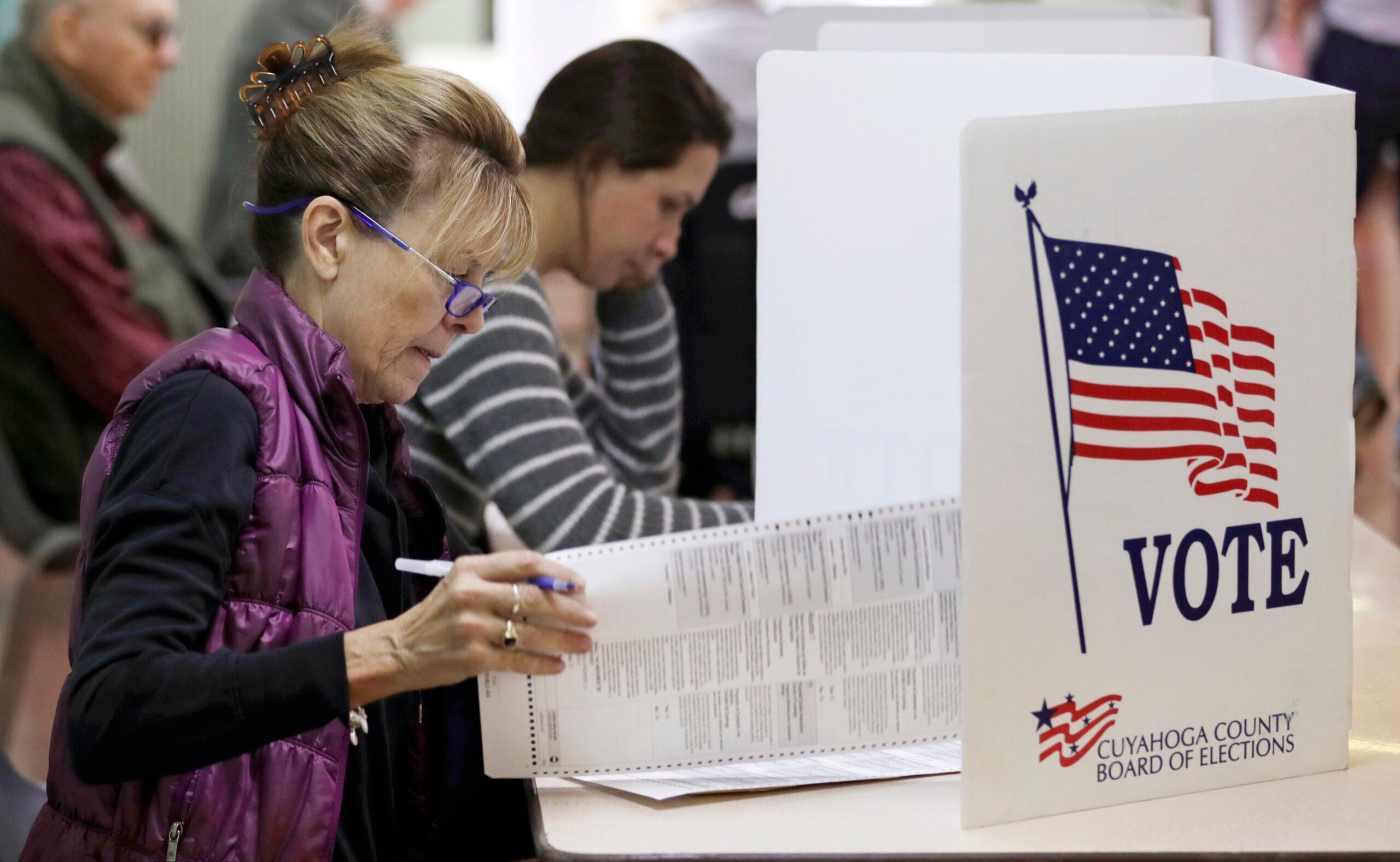 A woman looks over her voting ballot