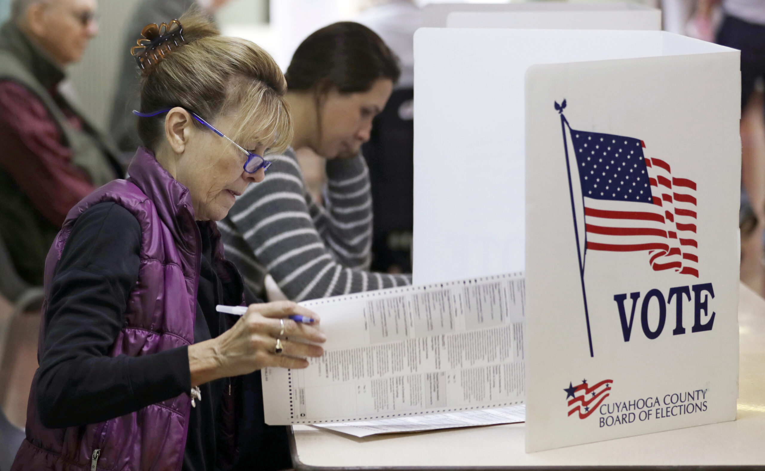 A woman looks over her voting ballot