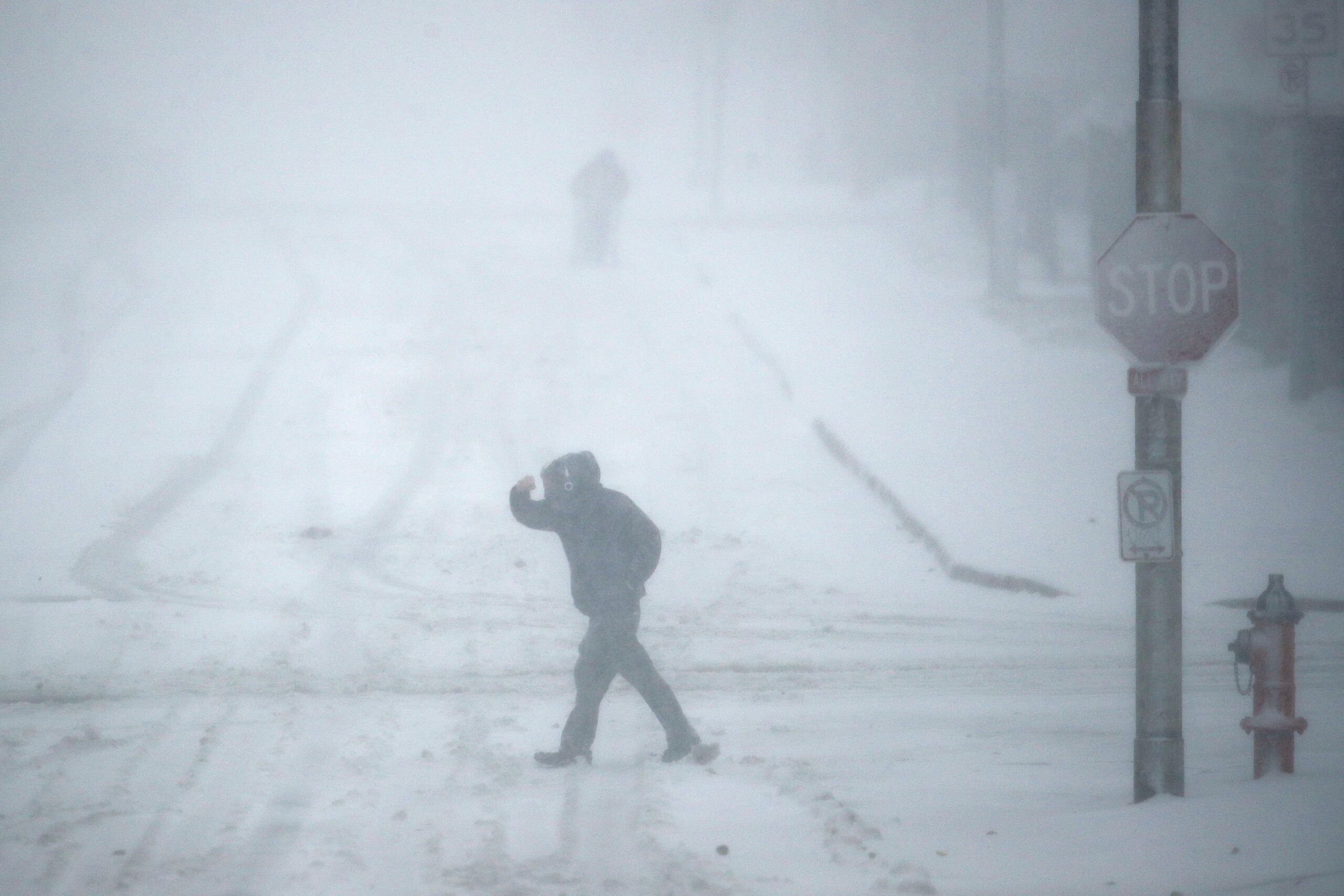 Pedestrians walk as snow falls