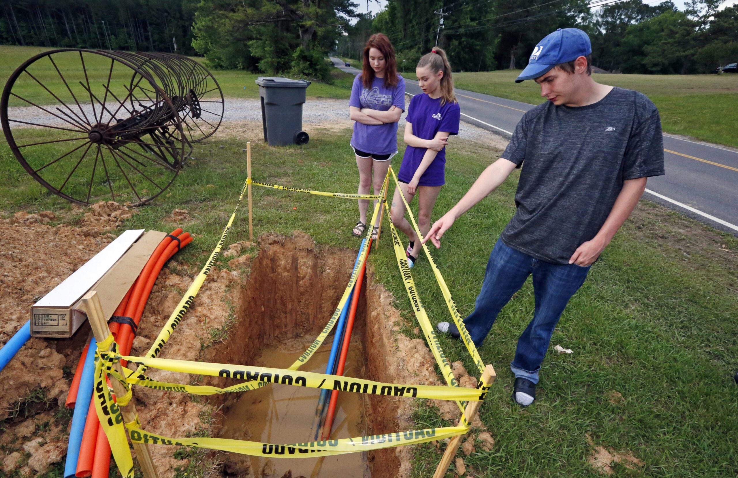siblings stand around a fiber-optic line