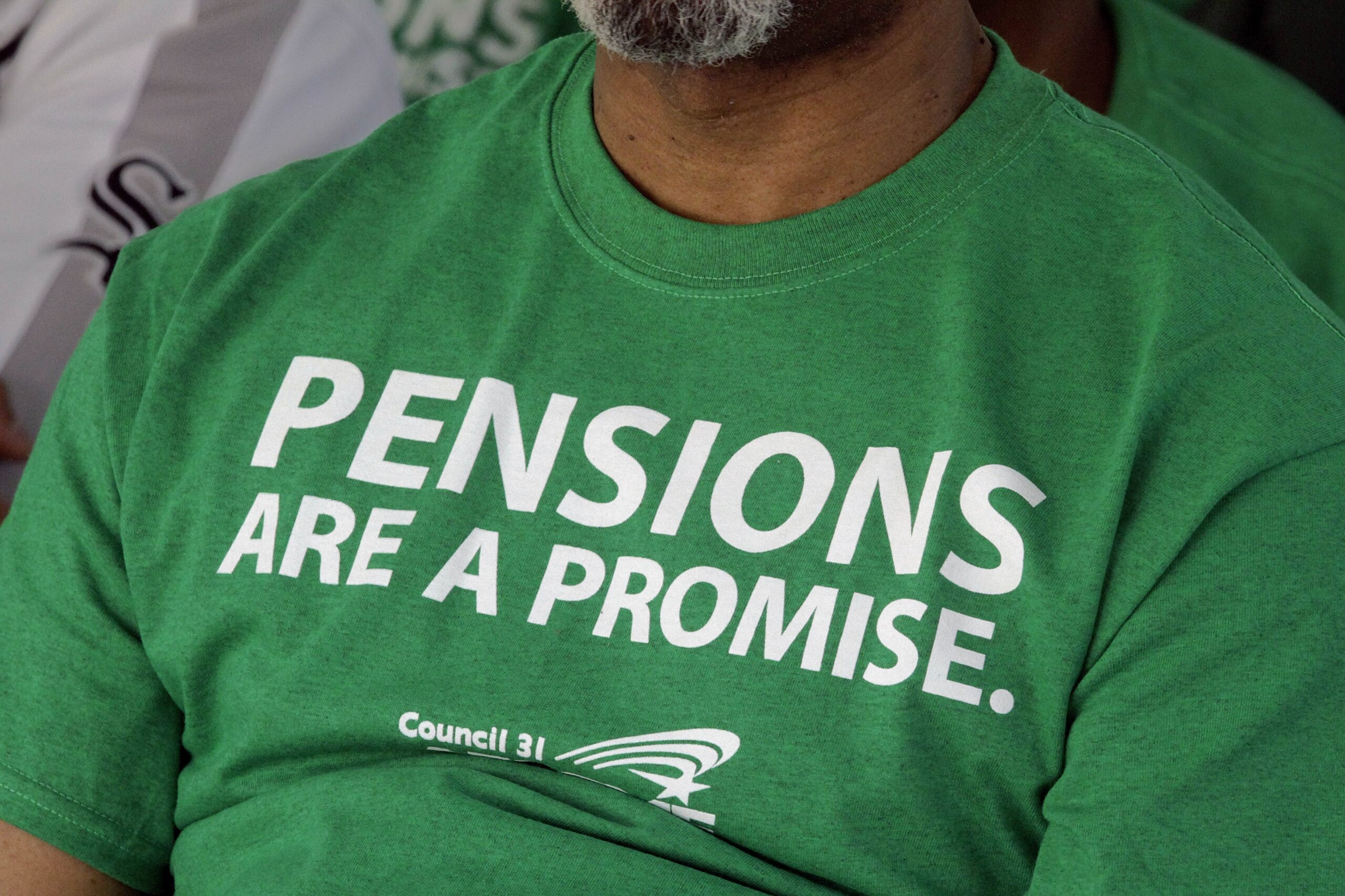 American Federation of State County and Municipal Employees union members wear a protest message on pensions