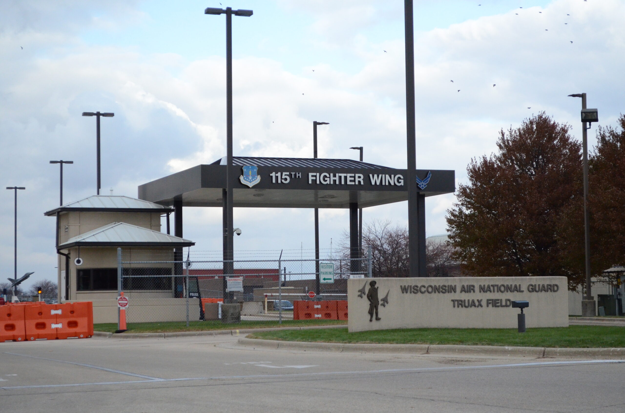 A sign for the Truax Field Air National Guard Base stands before a larger sign for the 115th Fighter Wing.