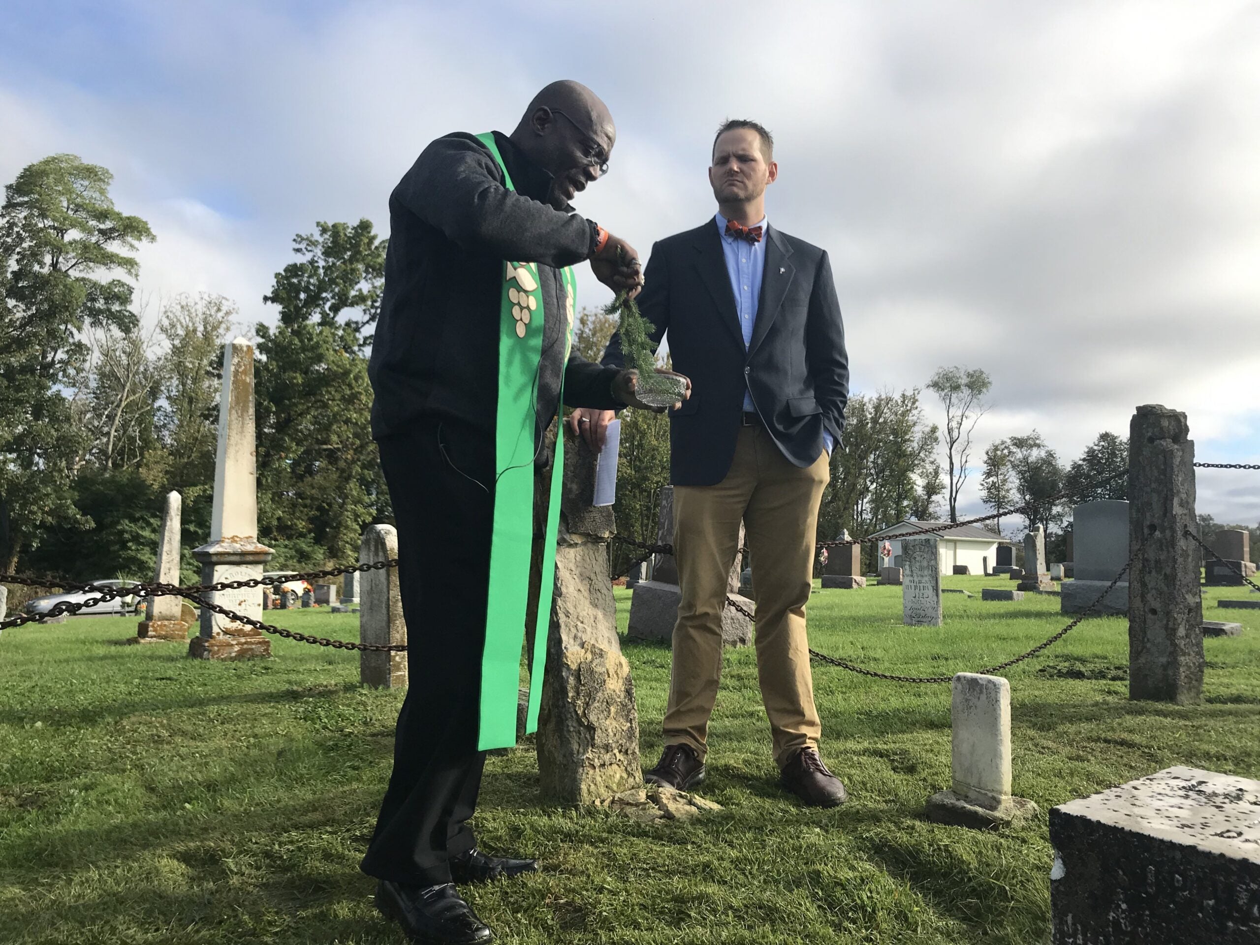 Rev. Gus Barnes baptizes the grave of Rachel