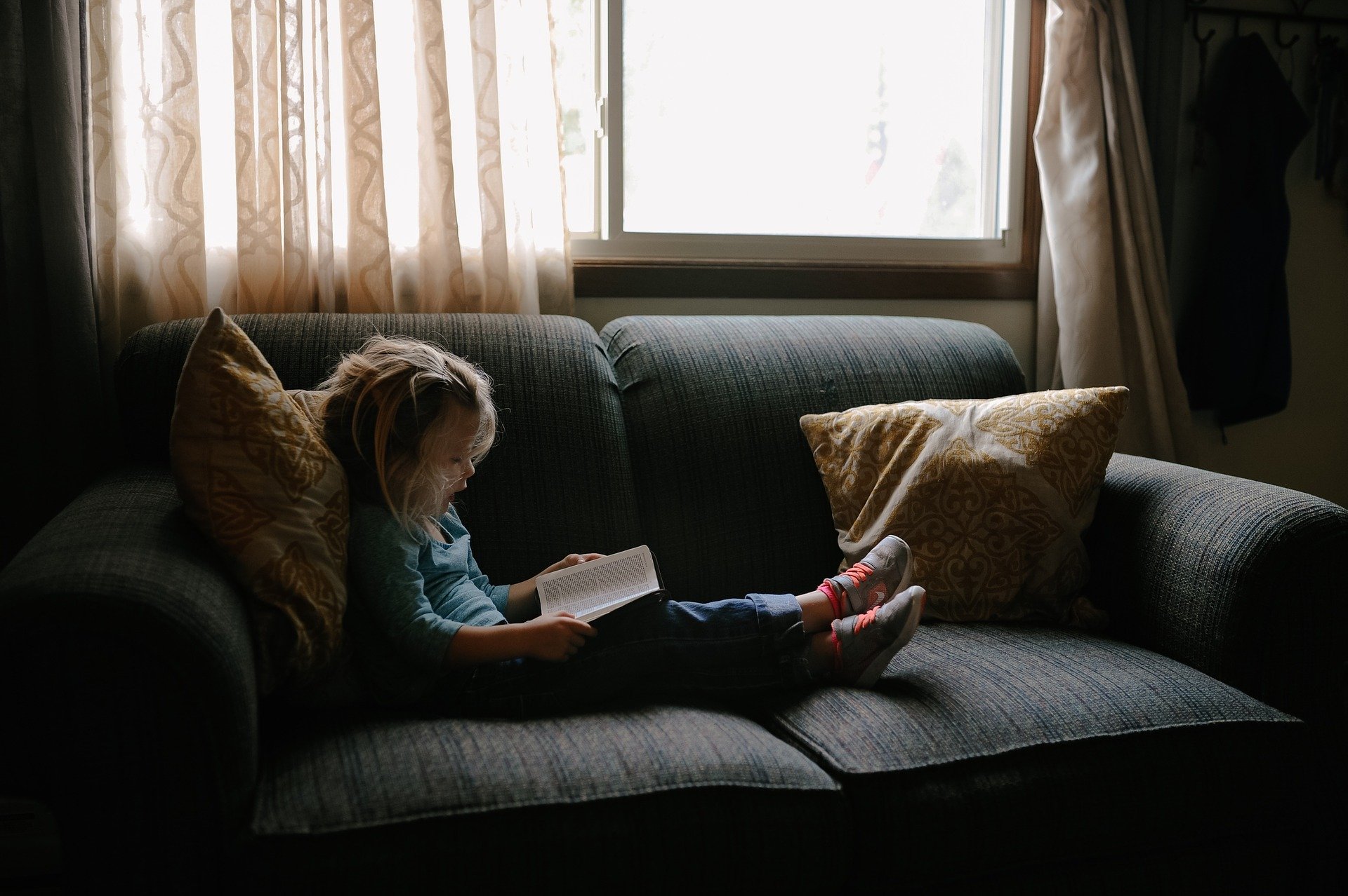 Child reading on couch.