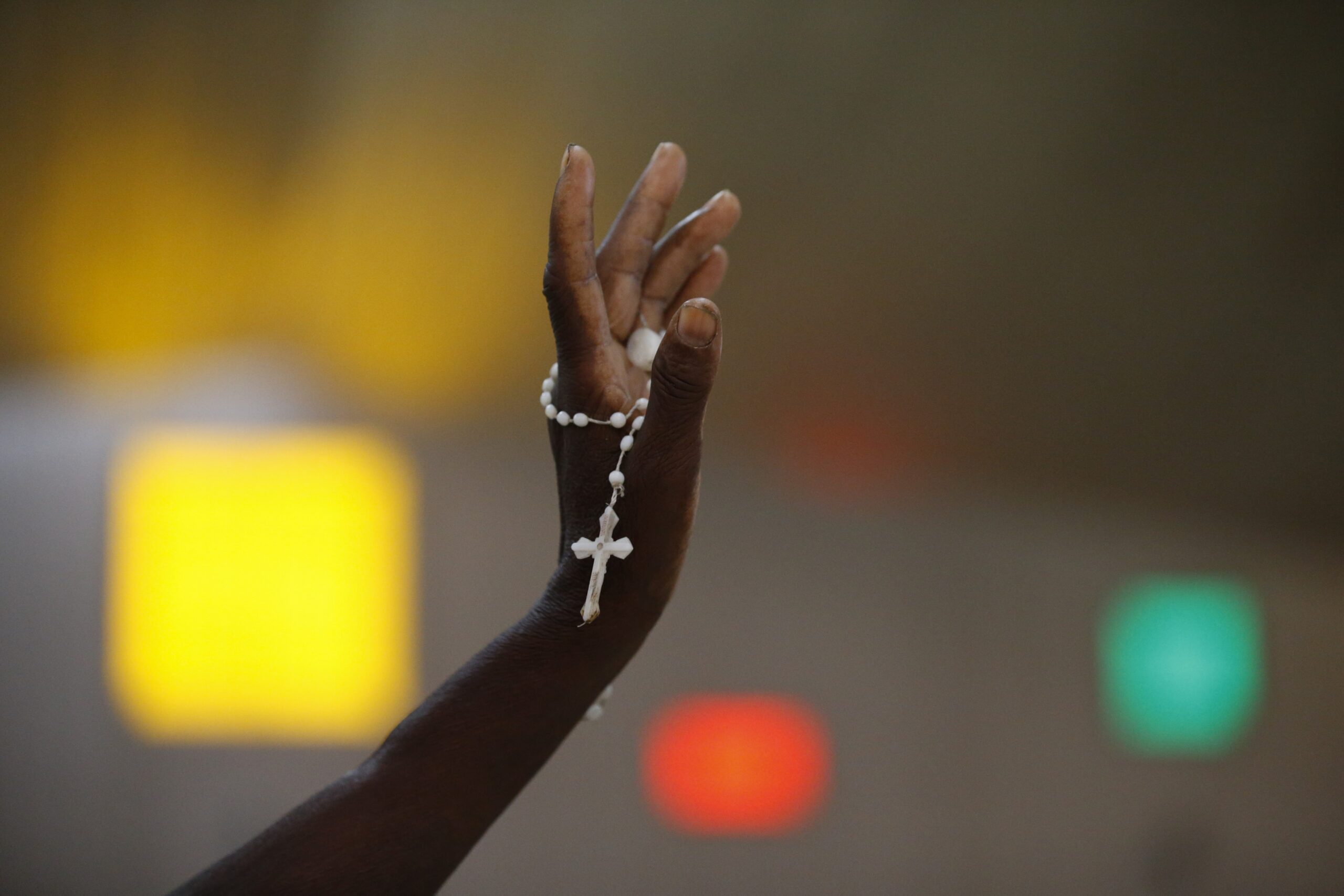 A hand holding a rosary