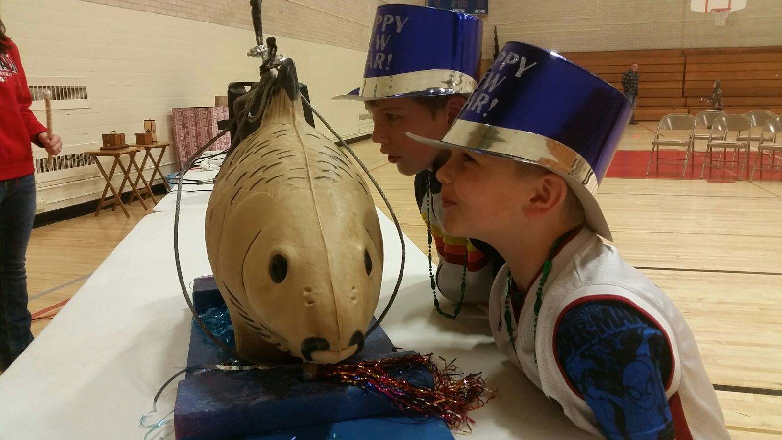 Two kids kiss Lucky the Carp at Carp Fest, a New Year's Eve celebration in Prairie du Chien