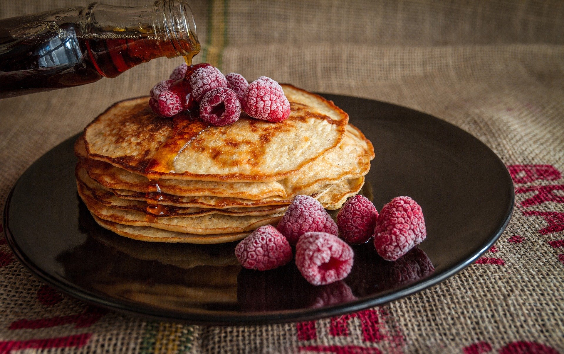 Pancakes with raspberries and maple syrup.