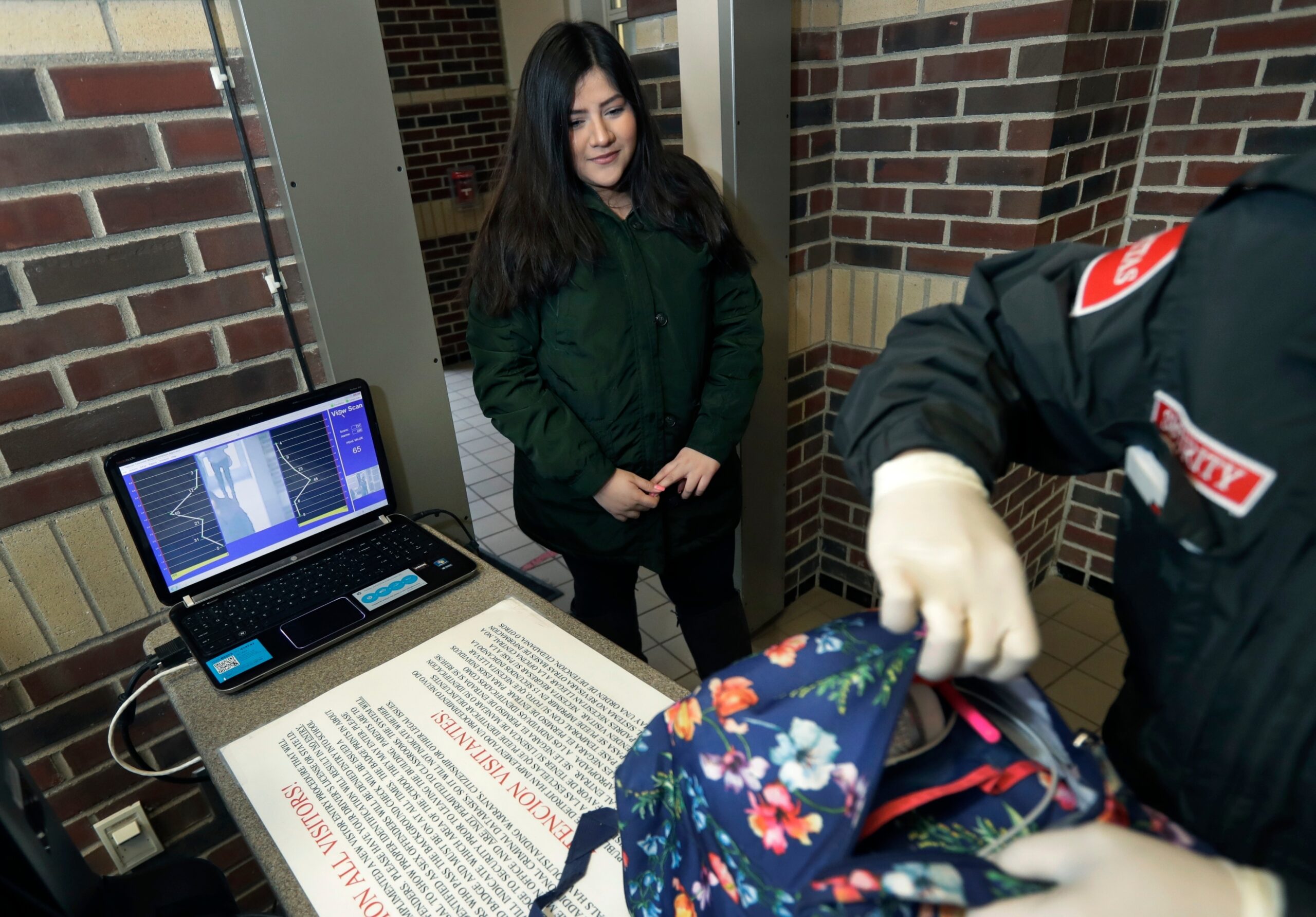 A student gets her bag checked at a metal detector