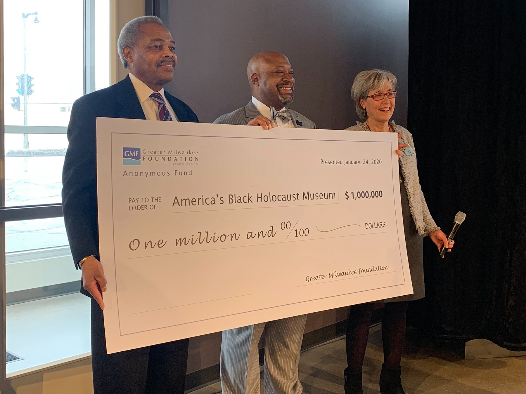A grant check presented to America's Black Holocaust Museum