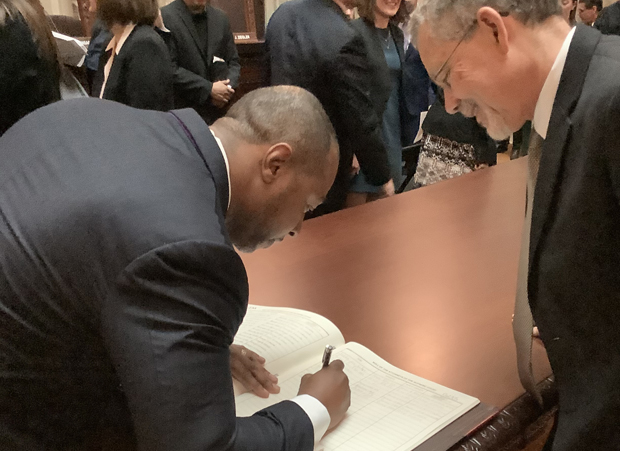 Jarrett Adams signs his name into the attorney book