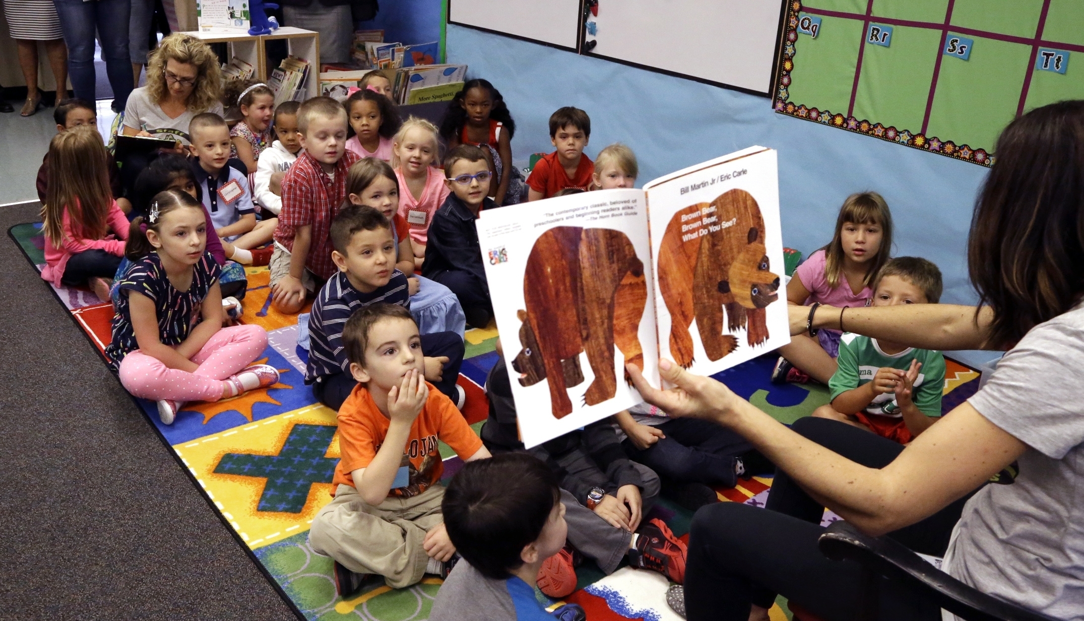 In this Sept. 8 2015, file photo, kindergarten students listen to teacher Amy Holland read