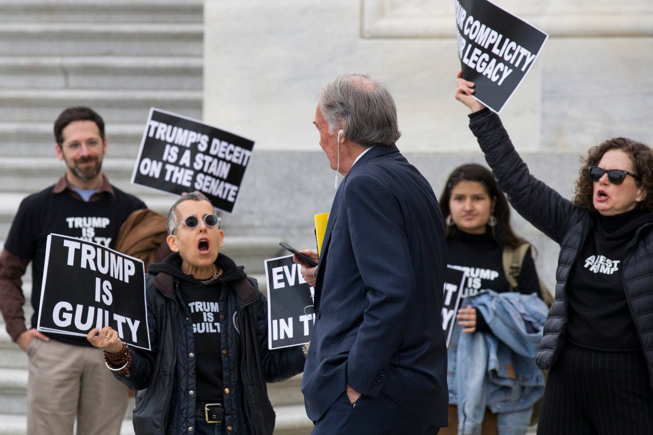 Sen. Ed Markey, D-Mass., third from right, walks past demonstrators