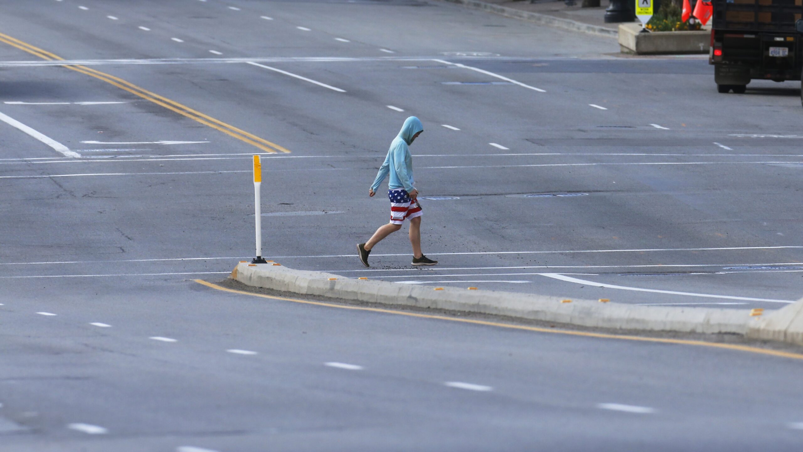 A person crosses an empty downtown street