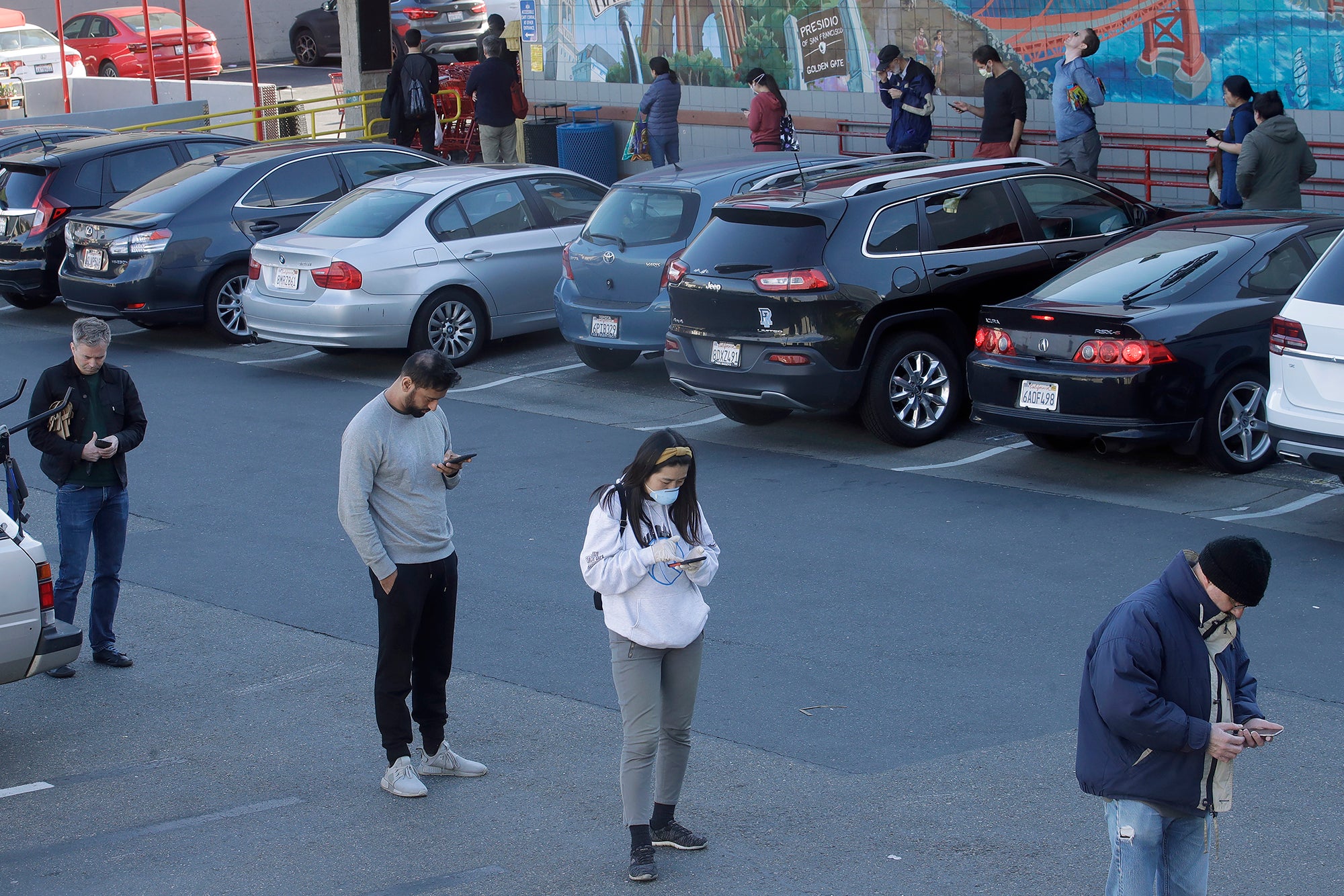 People standing in line outside a grocery store
