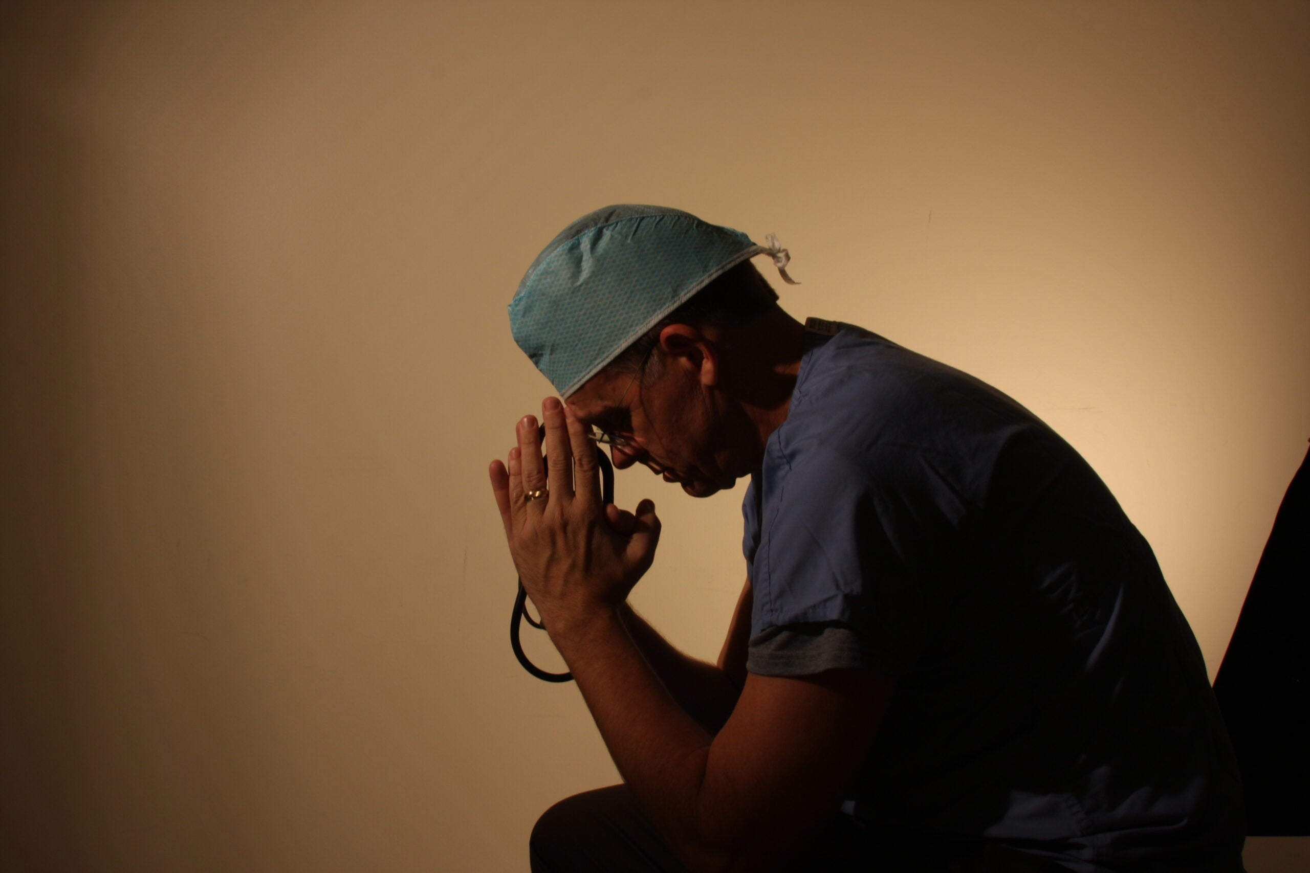 Doctor rests head on hands