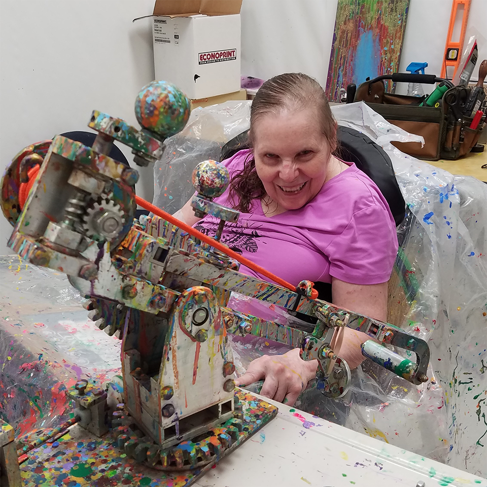 Jeanne Grosse poses with an aluminum paint catapult that she uses to create artwork