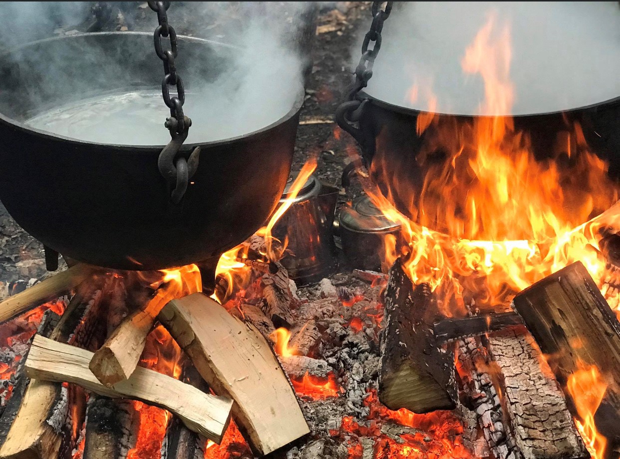 Maple sap boiling in cast iron pots over an open fire