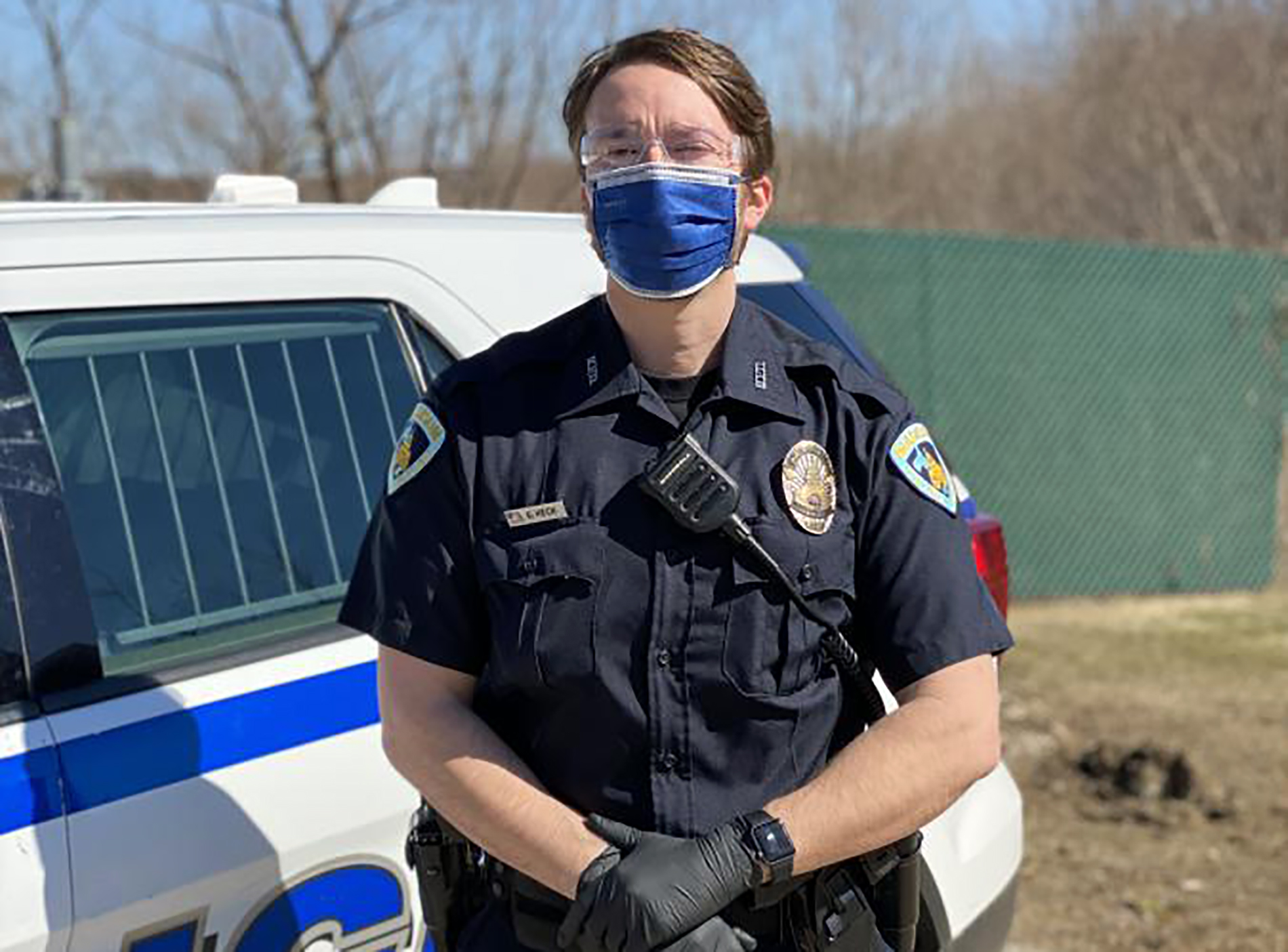 A police officer wears a mask and gloves.