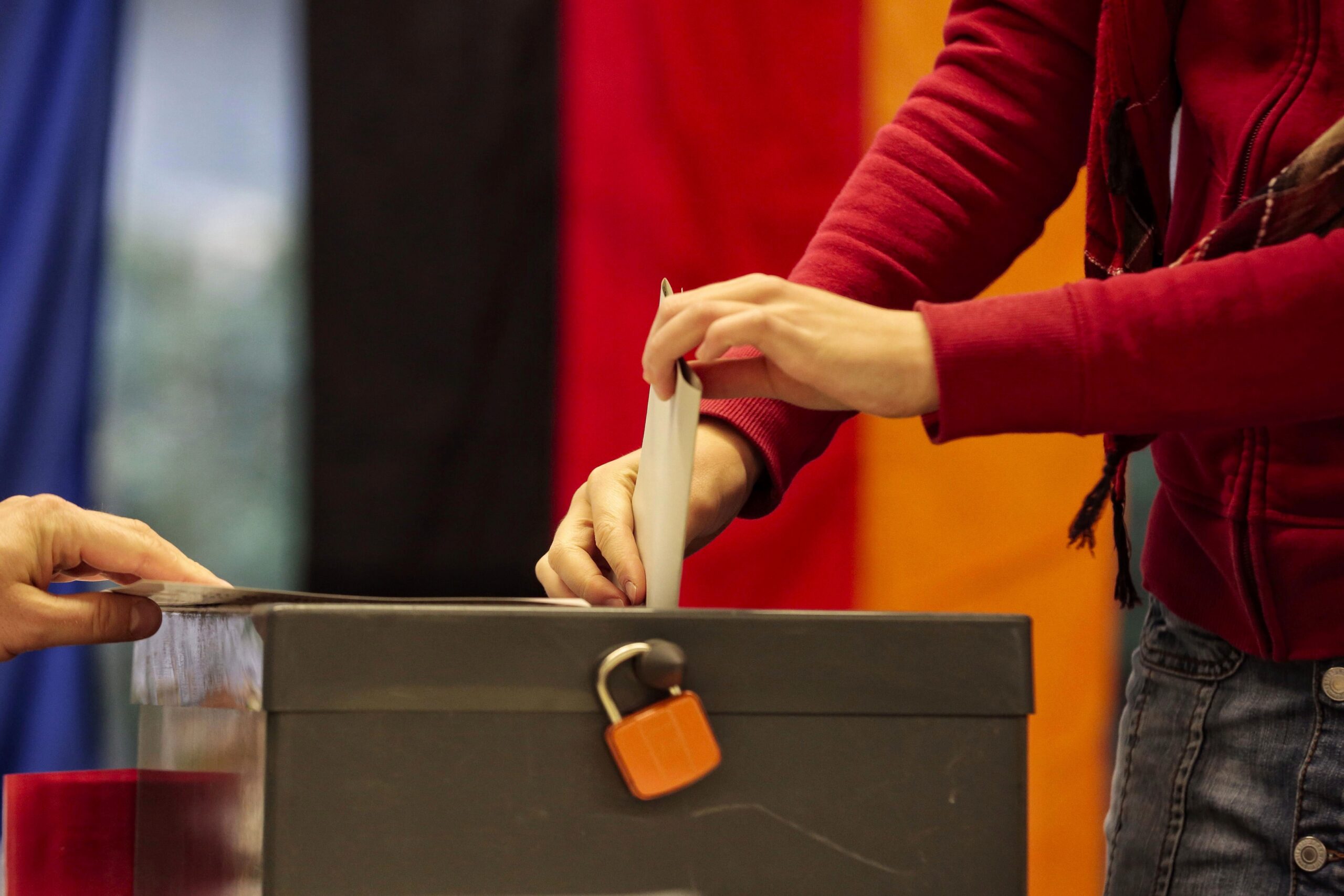 A person entering a ballot into a ballot box