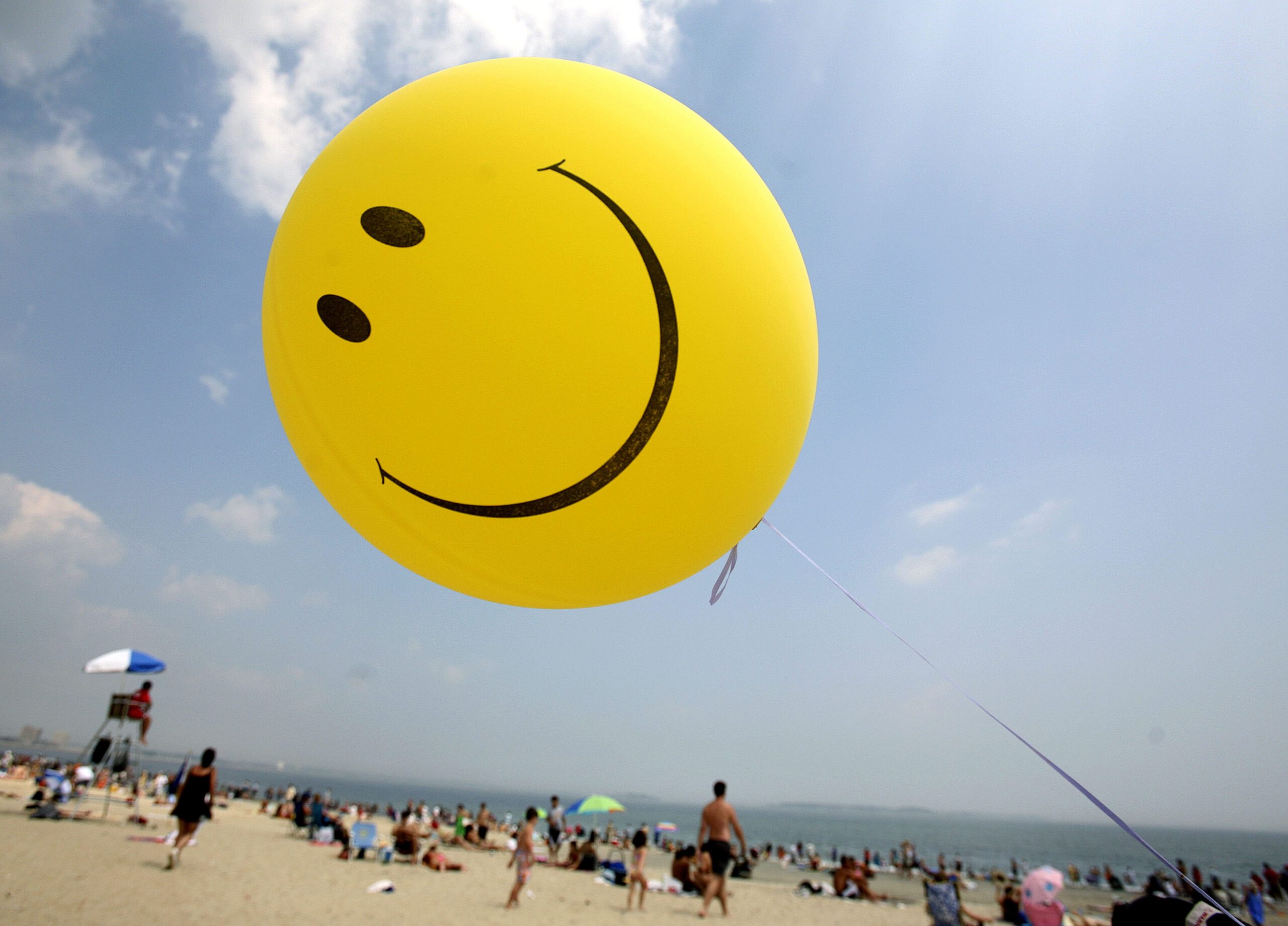 Smiley face balloon on the beach