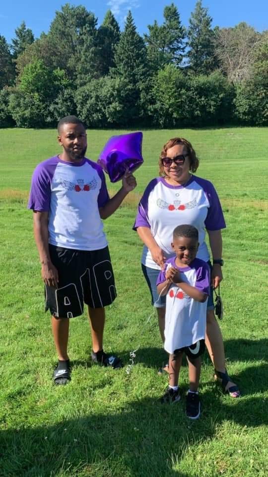 Adrienne Lathan poses for a photo outdoors with her family