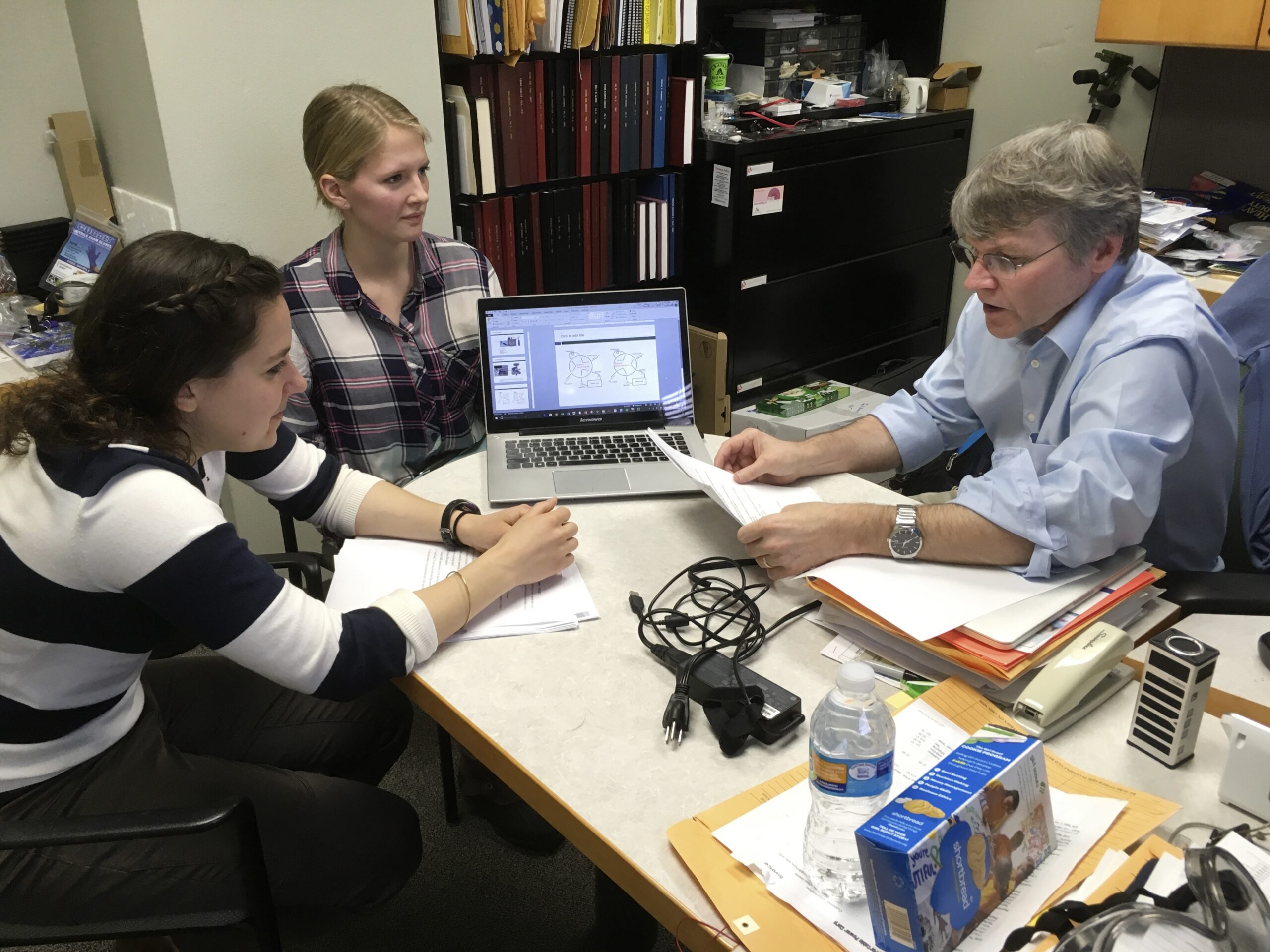 University of Wisconsin-Madison chemistry professor Robert Hamers confers with junior Alice Horein and doctoral candidate Sarah Guillot on their research projects during a meeting in Hamers' campus office.