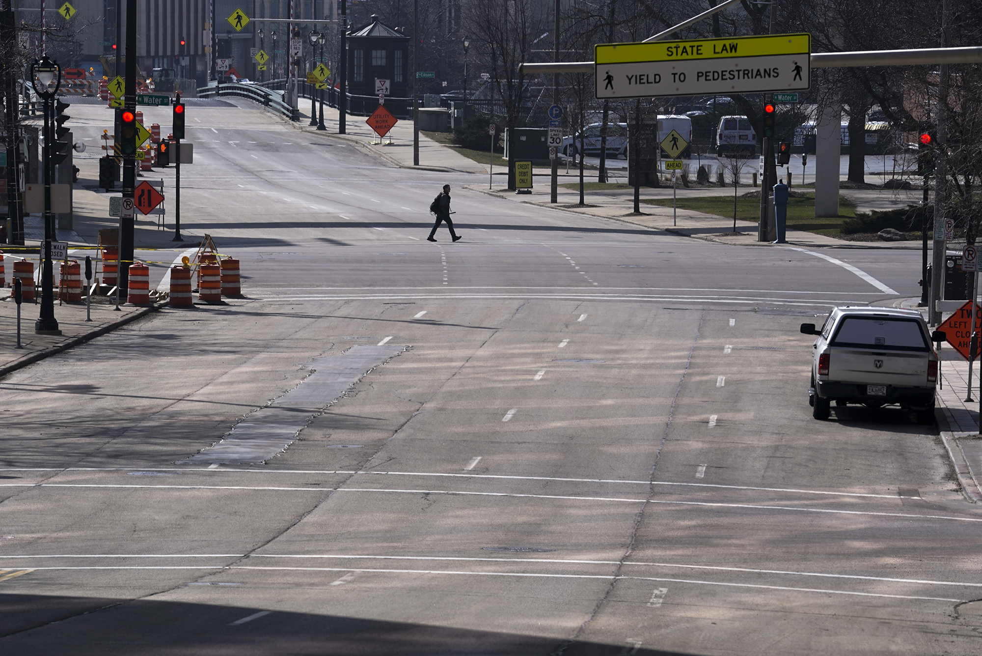 A pedestrian walks across an empty State Street in Milwaukee