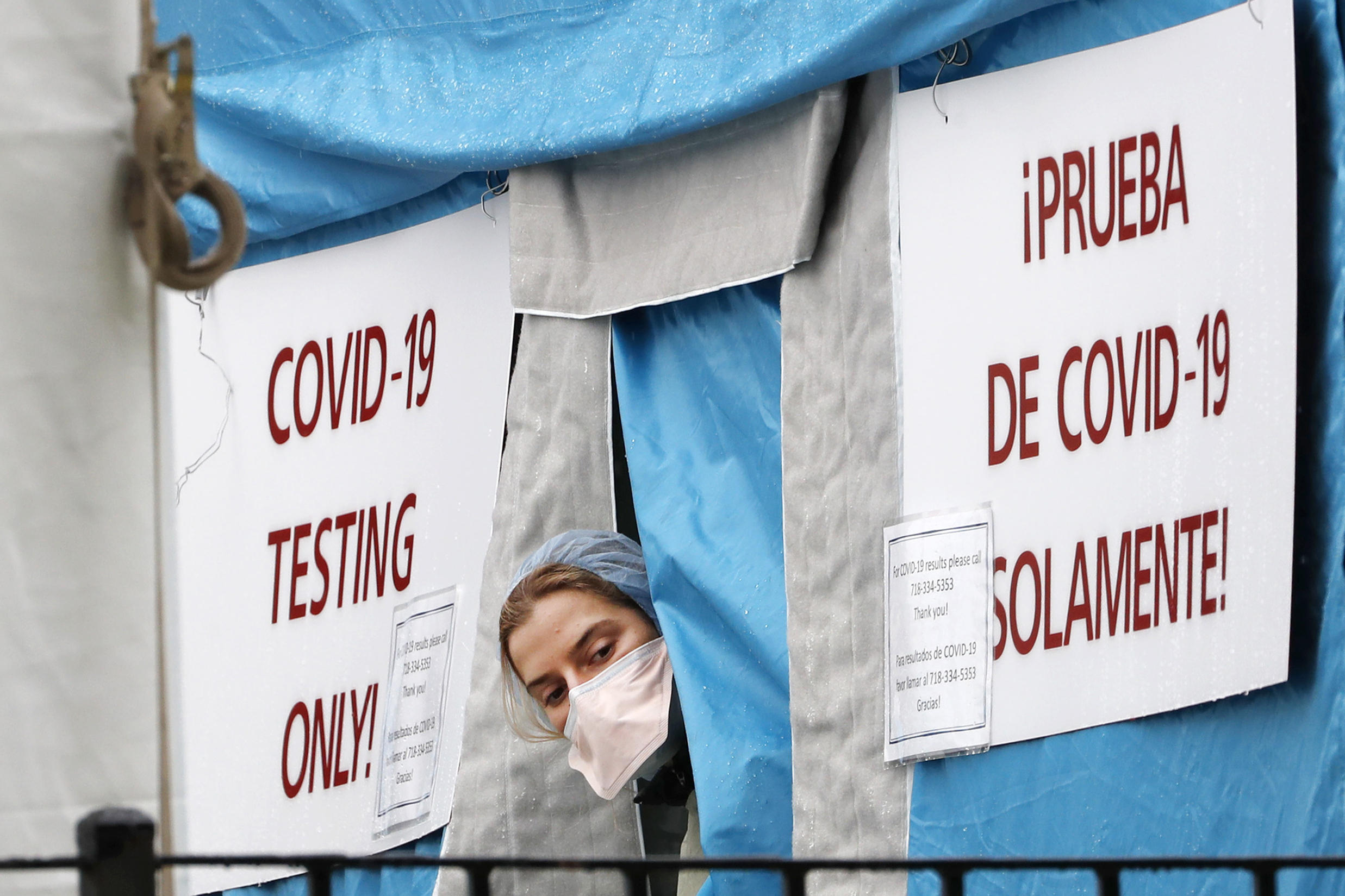 A medical worker sticks her head outside a COVID-19 testing tent