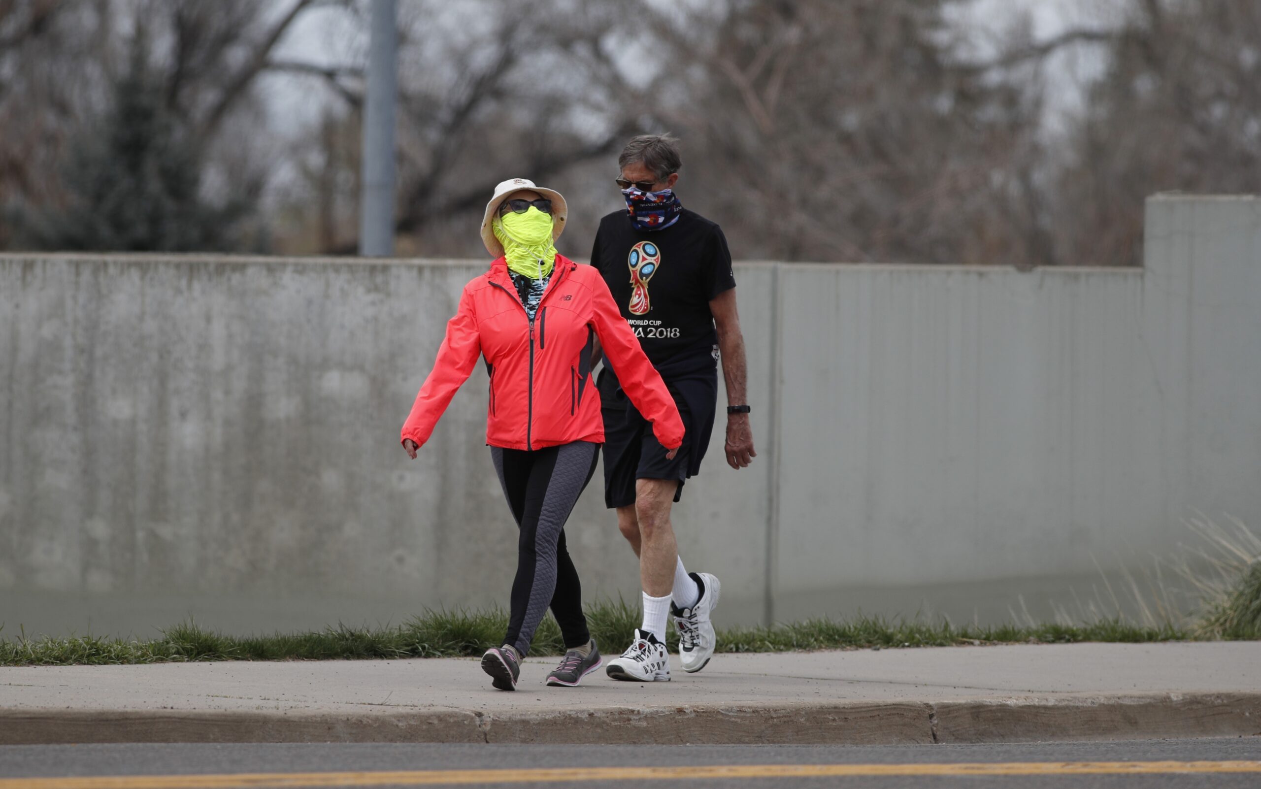 Pedestrians wear masks as they walk outside