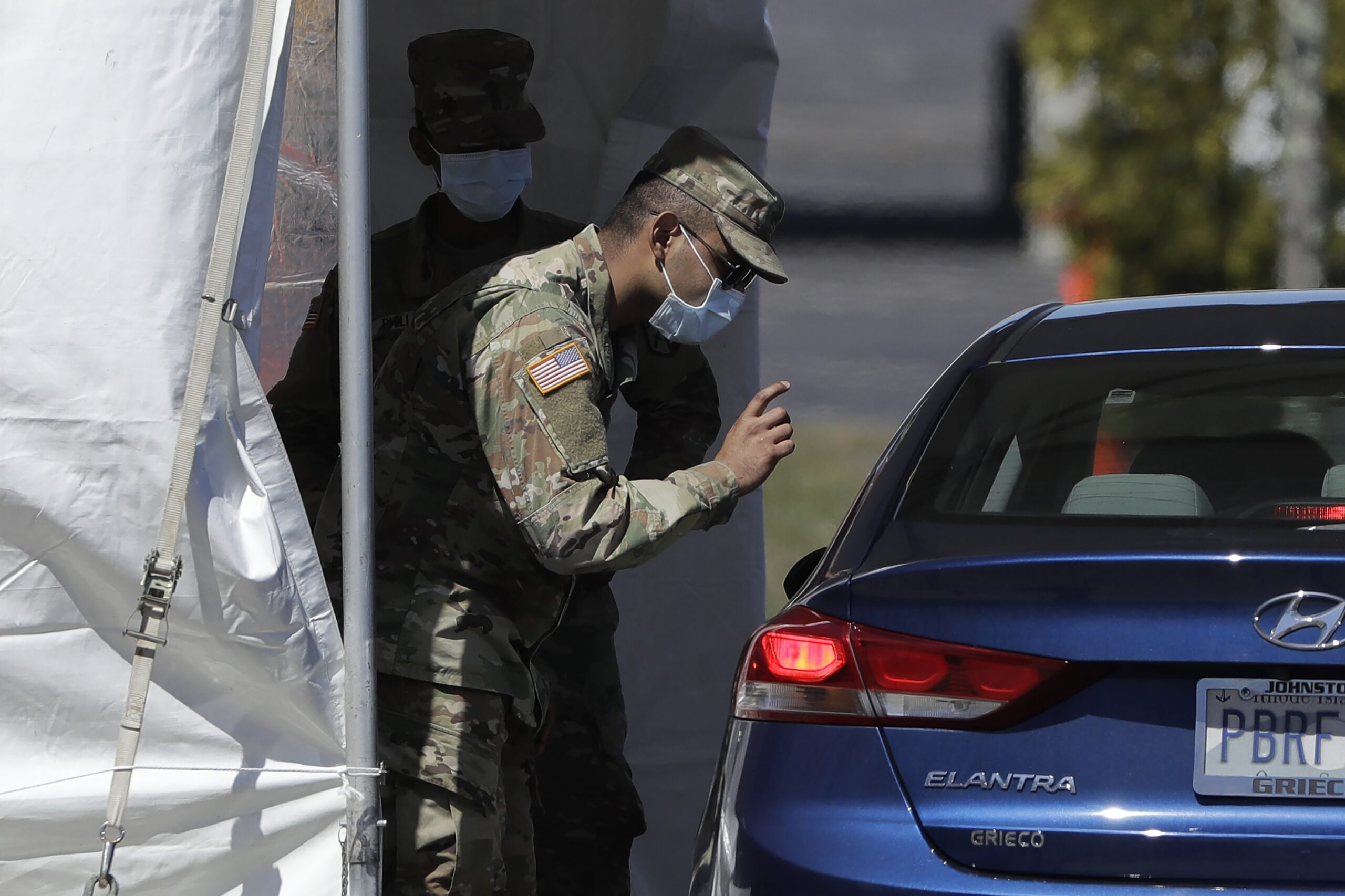 National Guard greets a visitor in a vehicle at a coronavirus testing site