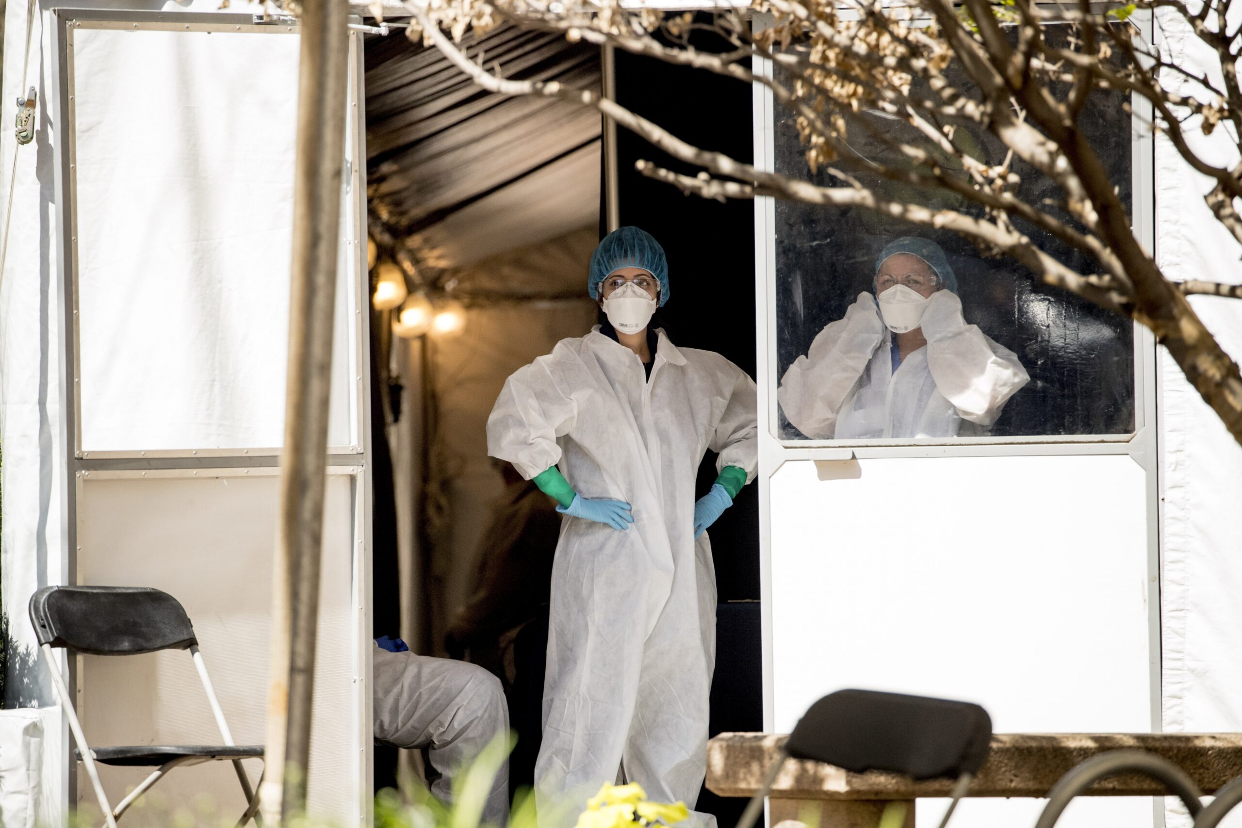 Medical workers stand at the door to a coronavirus testing site