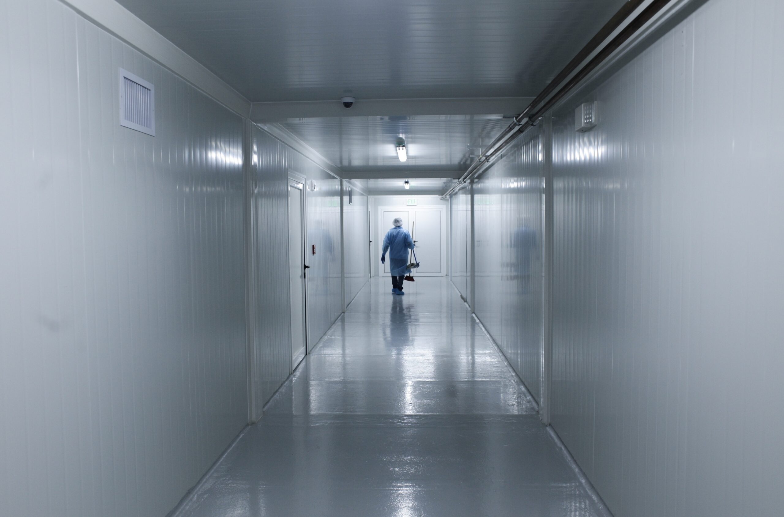 A worker wearing protective gear walks down the corridor of a new health facility