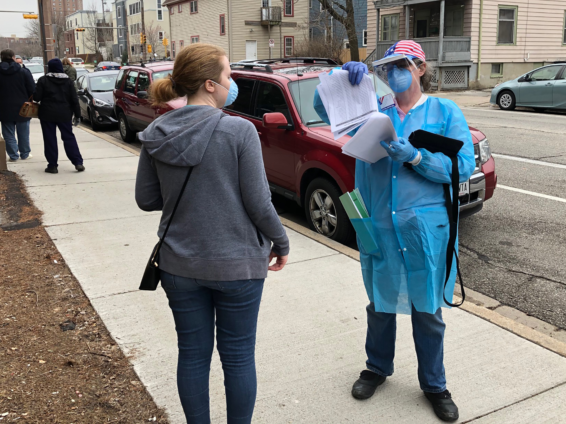 Caroline Hildebrand talks to a poll worker with the Wisconsin National Guard