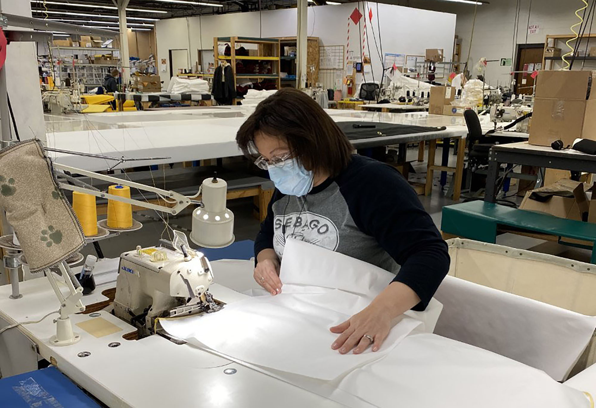 Stormy Kromer employee Penny Linnemanstons sews gowns that are being produced for health care workers