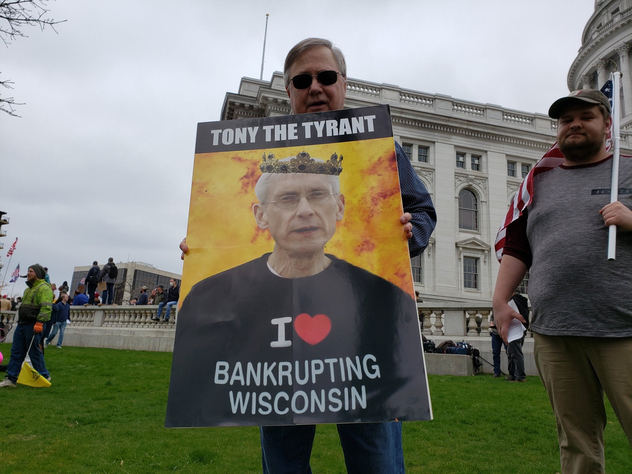 protester holds sign against safer at home order