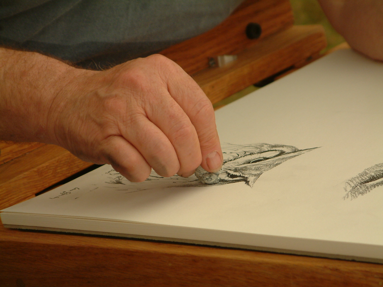A person works on a drawing of an owl.