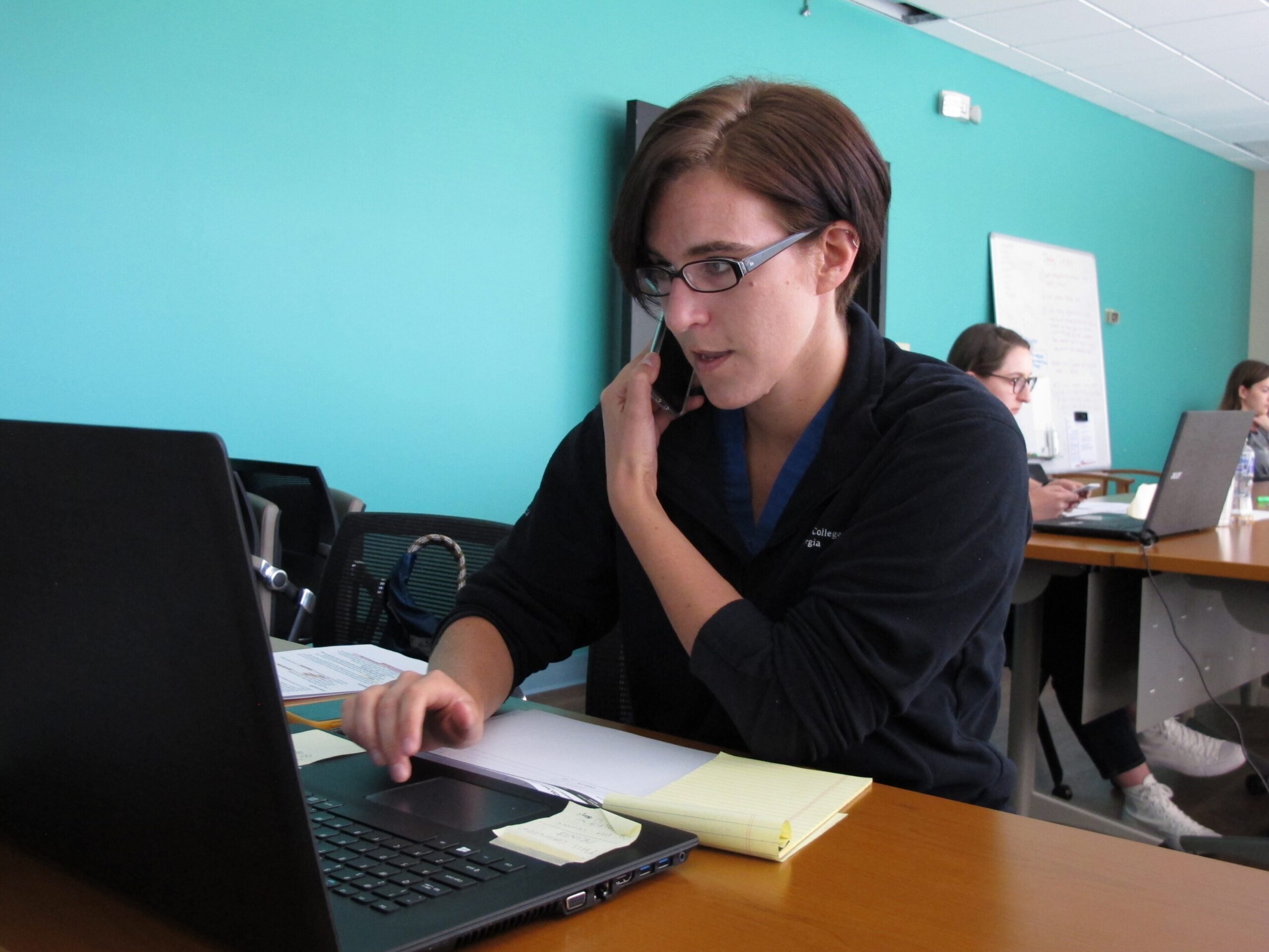 Rebecca DeCarlo talks on the phone conducting a follow-up interview with a person being monitored for COVID-19