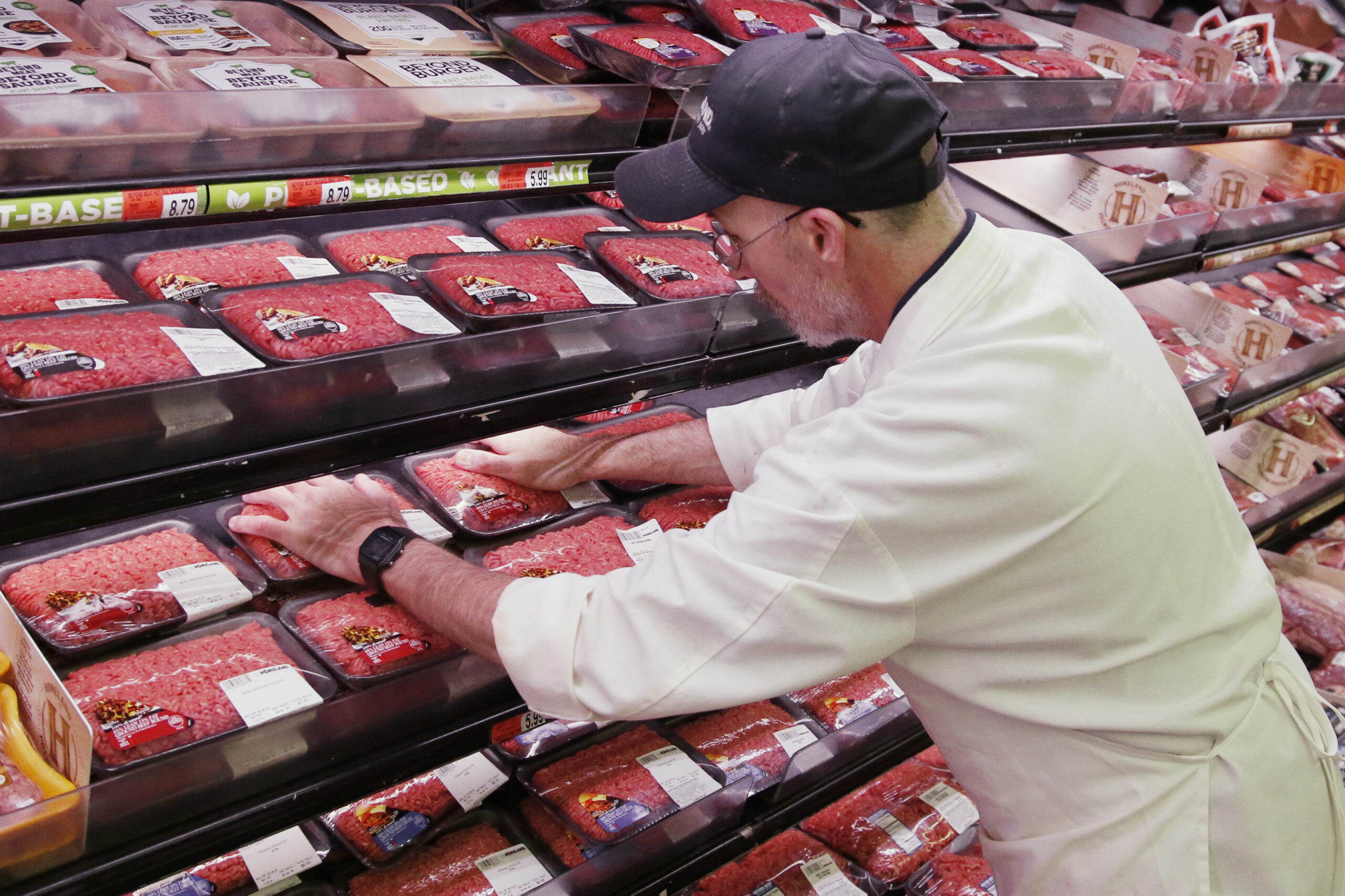A grocer stocks meat during the coronavirus pandemic