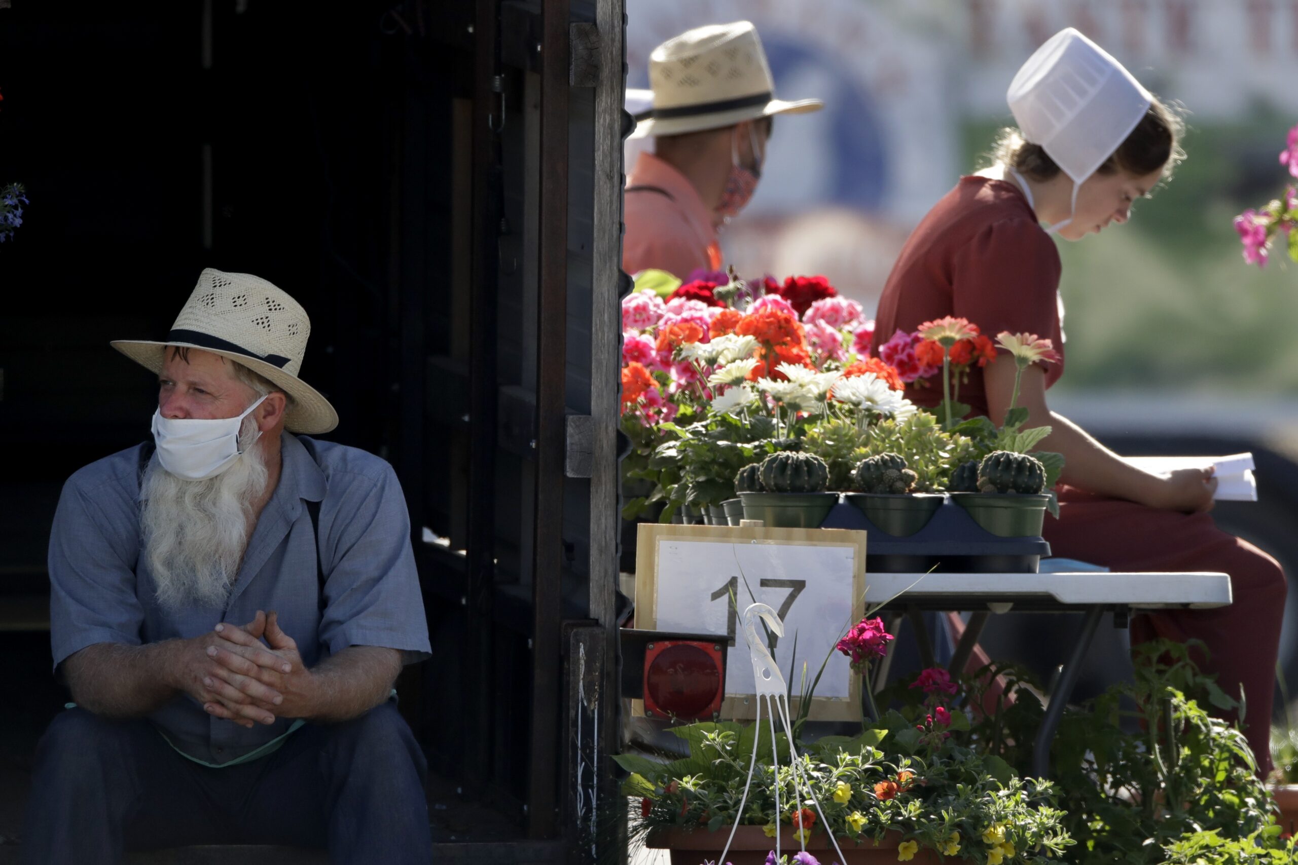 Vendors wait for customers at a drive-thru farmers market