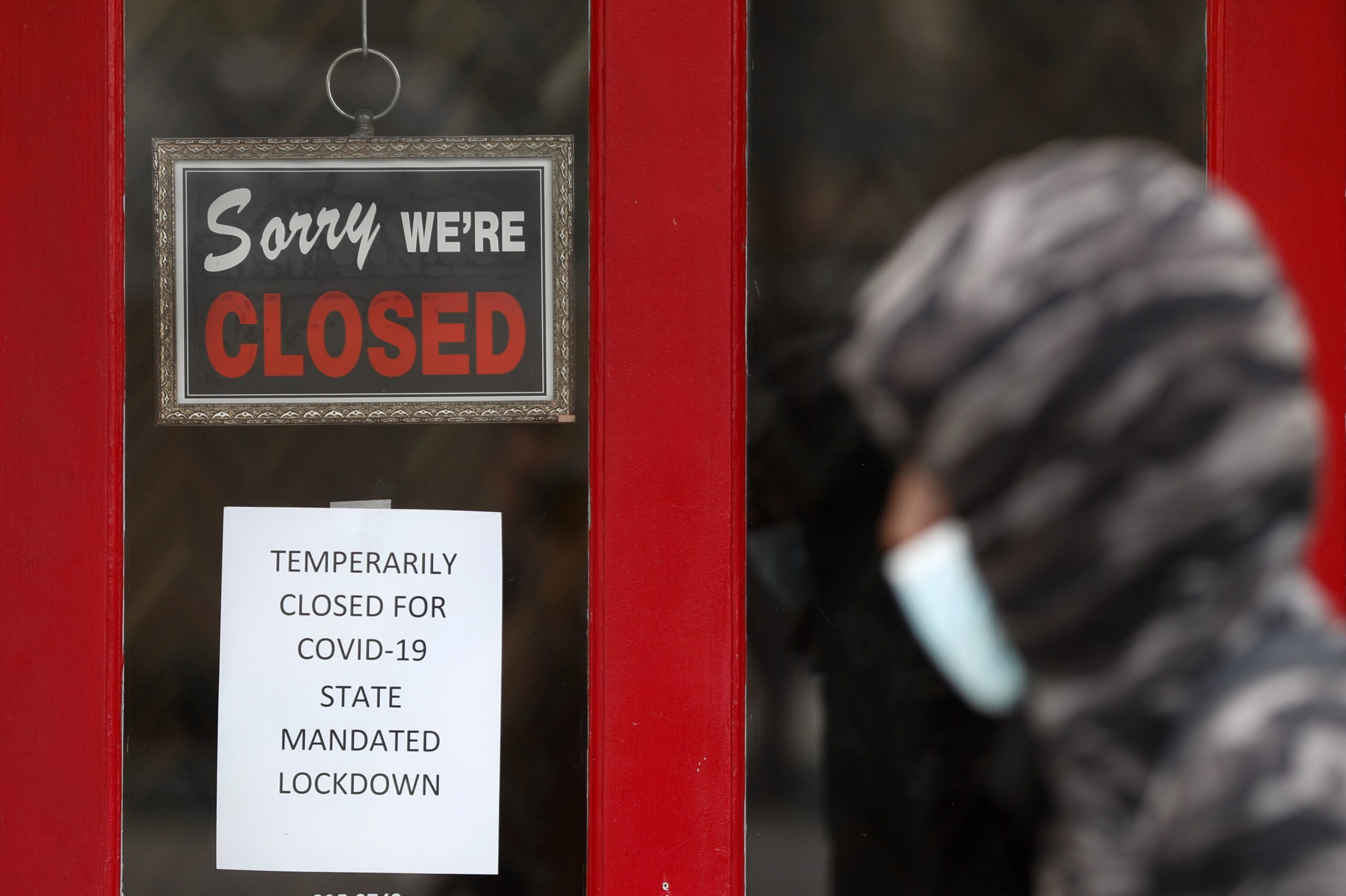 'Sorry We're Closed' sign hangs on business