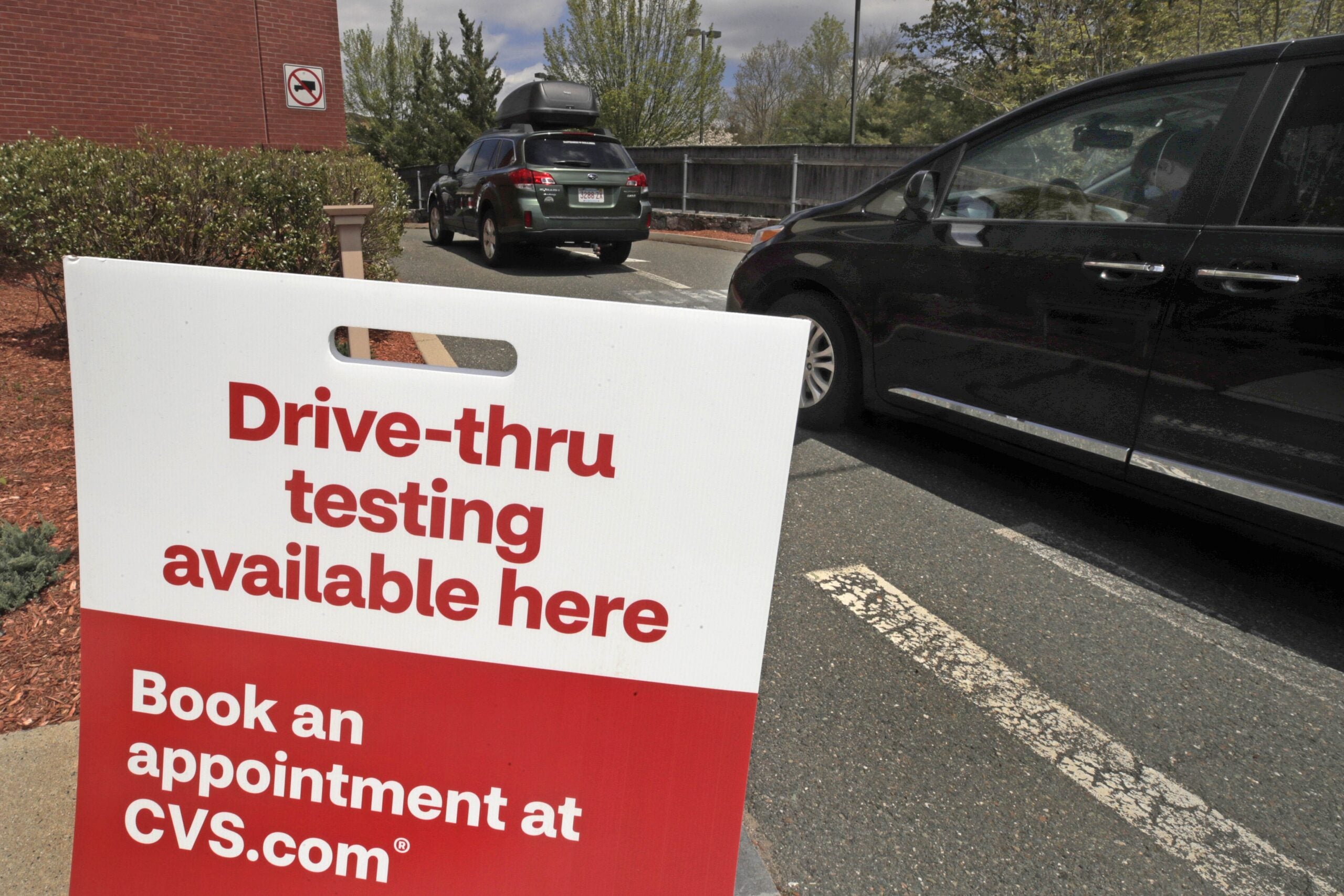 Cars idle in line as patients wait to self-take a COVID-19 virus test