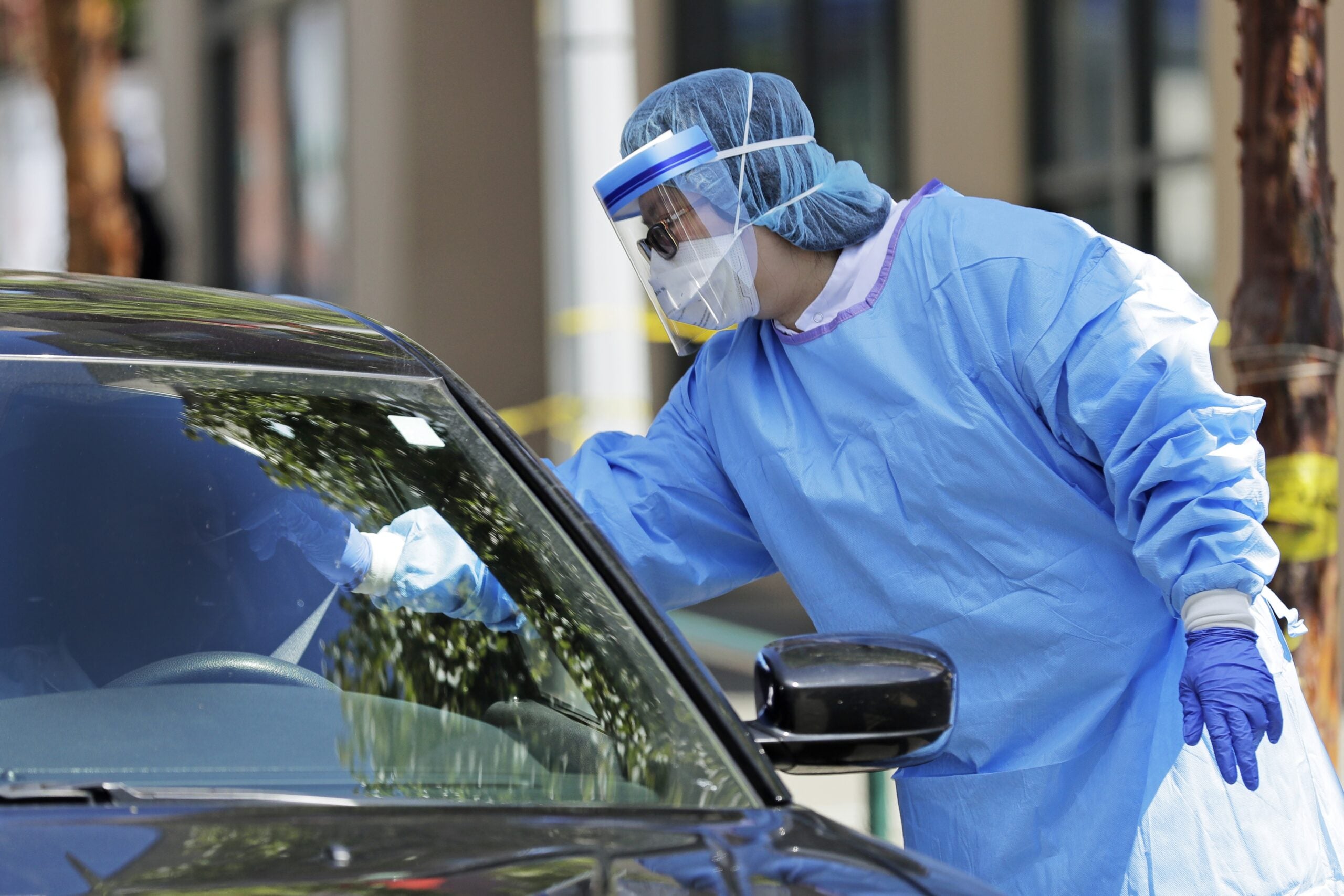 A nurse takes a nose swab sample for a COVID-19 test