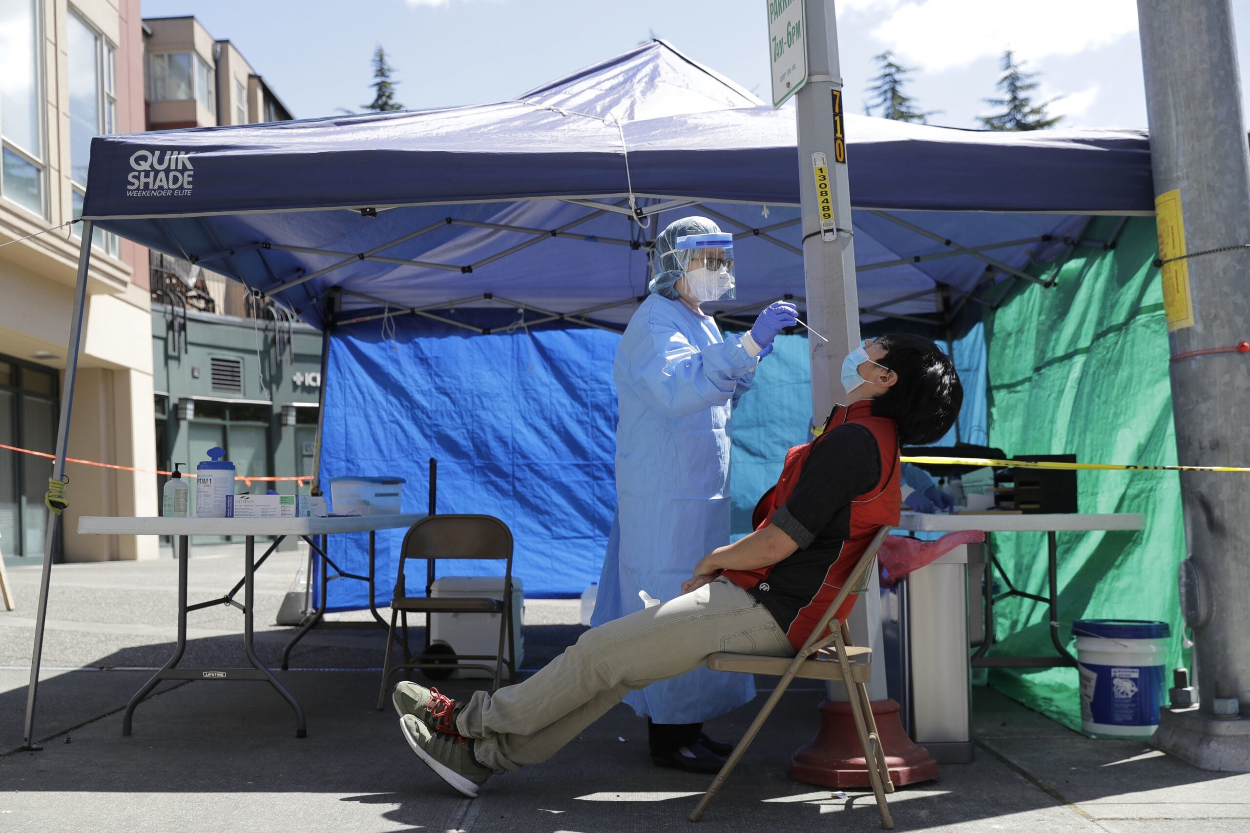 A nurse takes a nose swab sample for a COVID-19 test