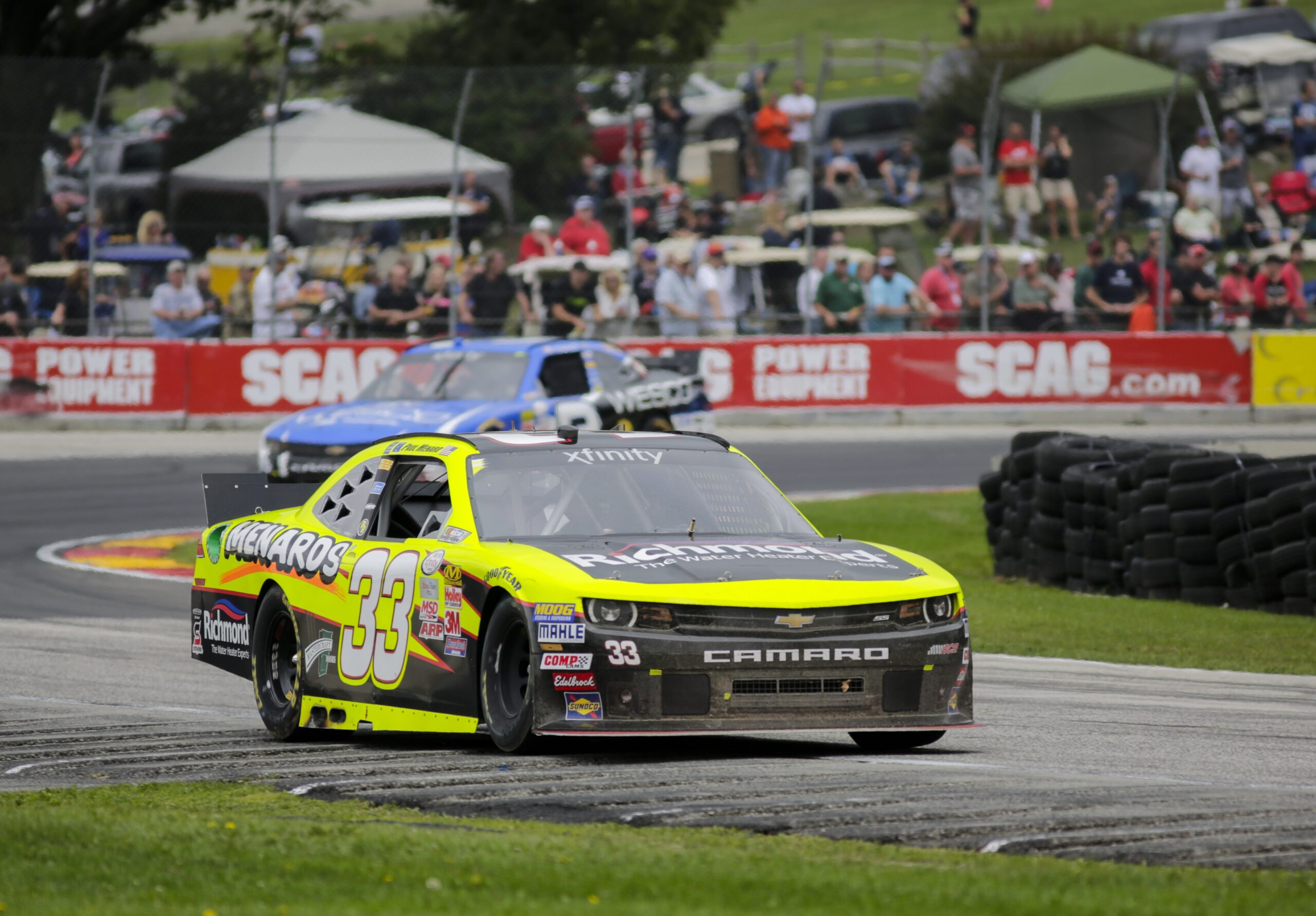 Paul Menard competes in a NASCAR race at Road America