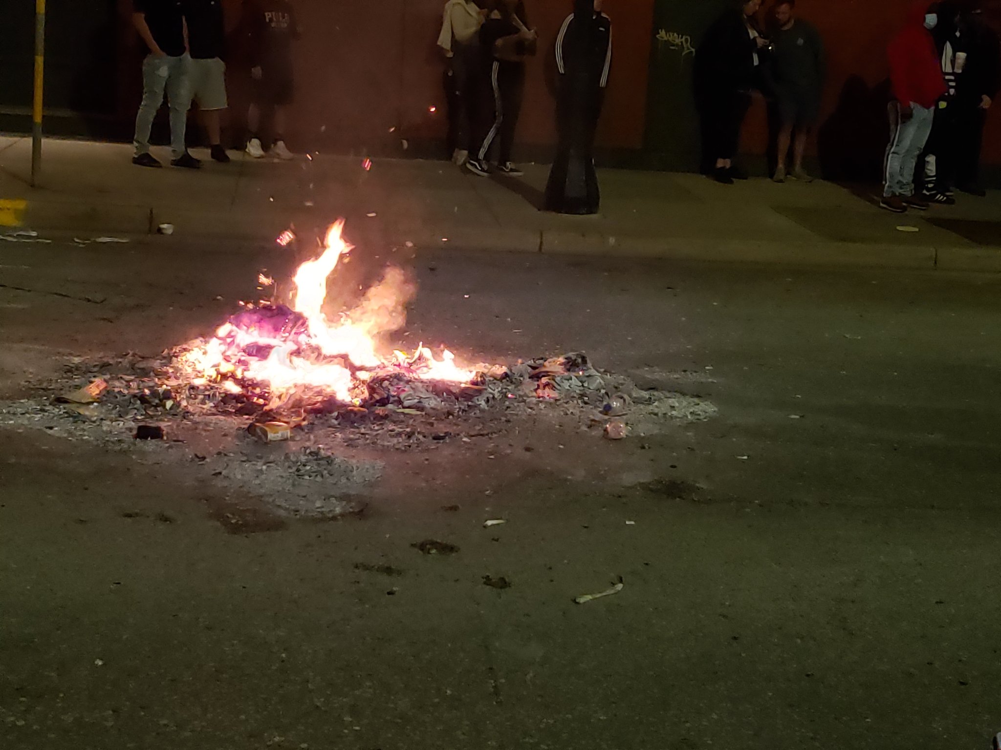 A trash fire smolders near State Street in downtown Madison Saturday night.