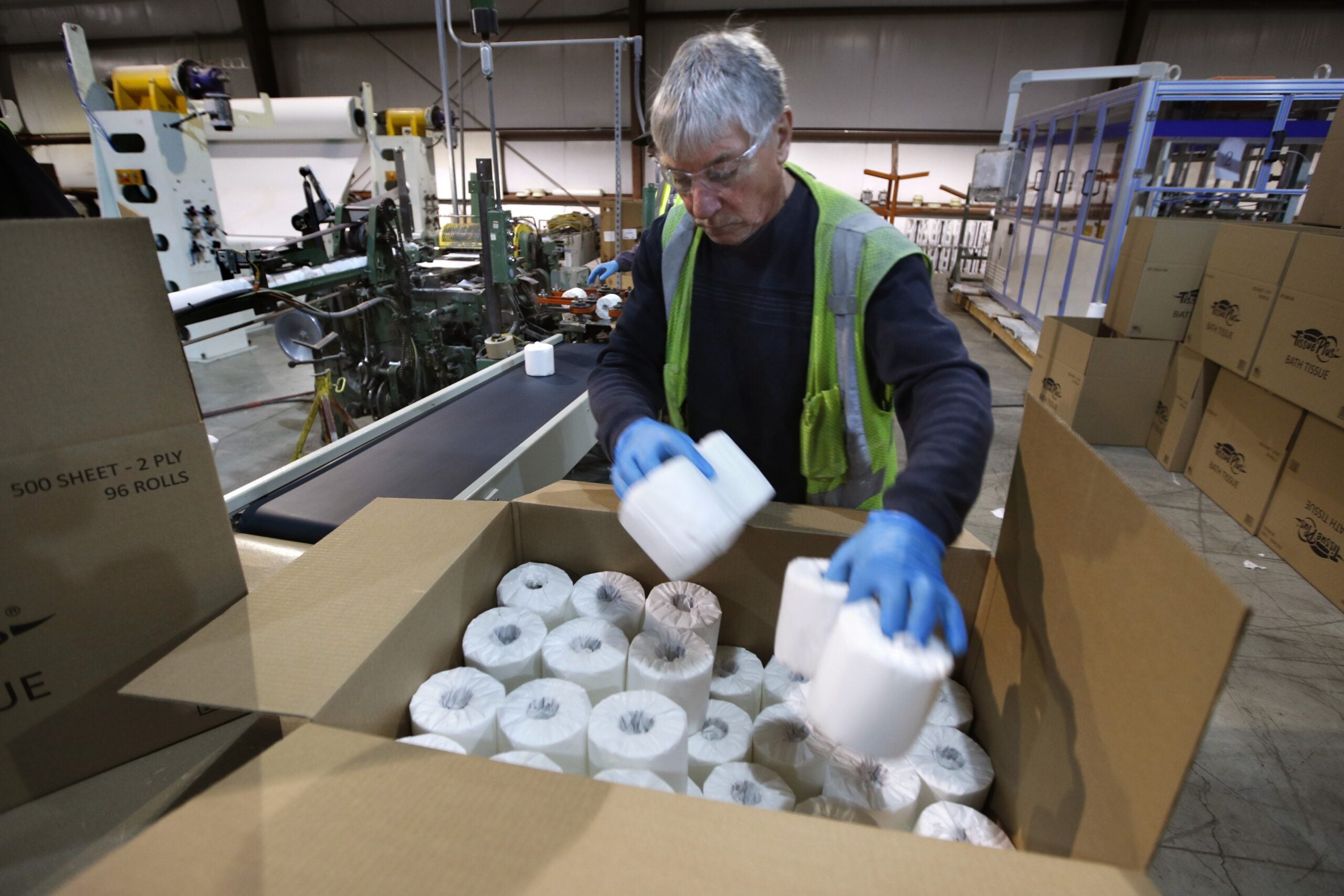 Worker fills a box with toilet paper at the Tissue Plus factory
