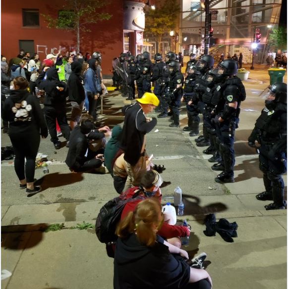 Protesters face off against police near State Street in downtown Madison on Saturday night.