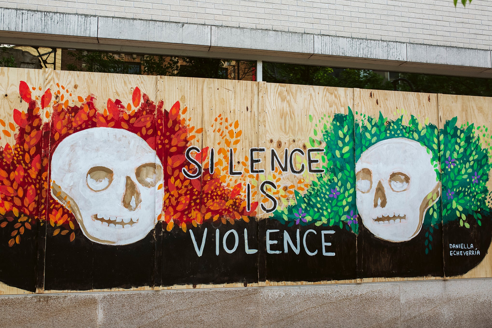 Artwork by Daniella Echeverría is displayed on boarded up store windows on State Street