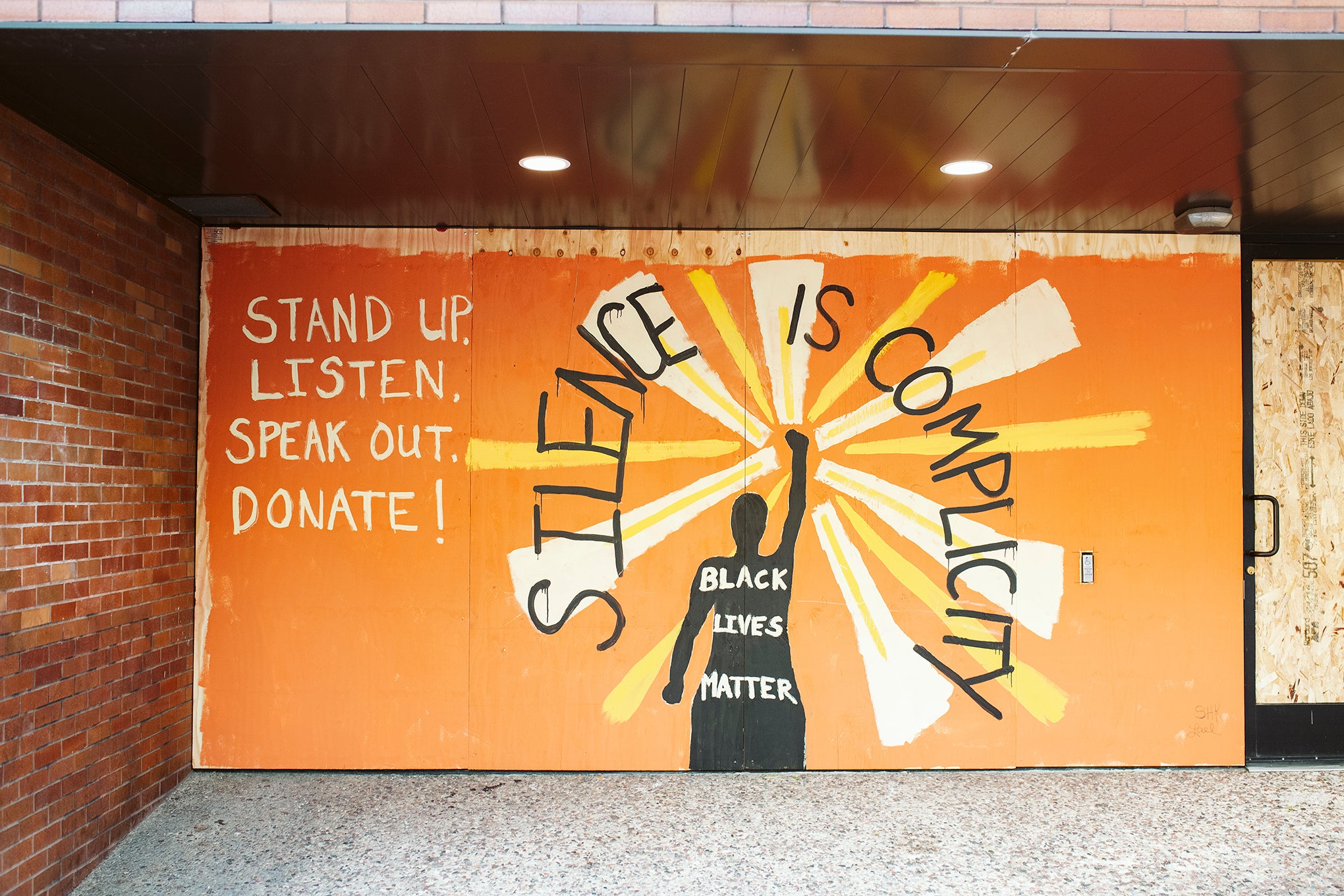 Artwork is displayed on boarded up store windows on State Street in downtown Madison