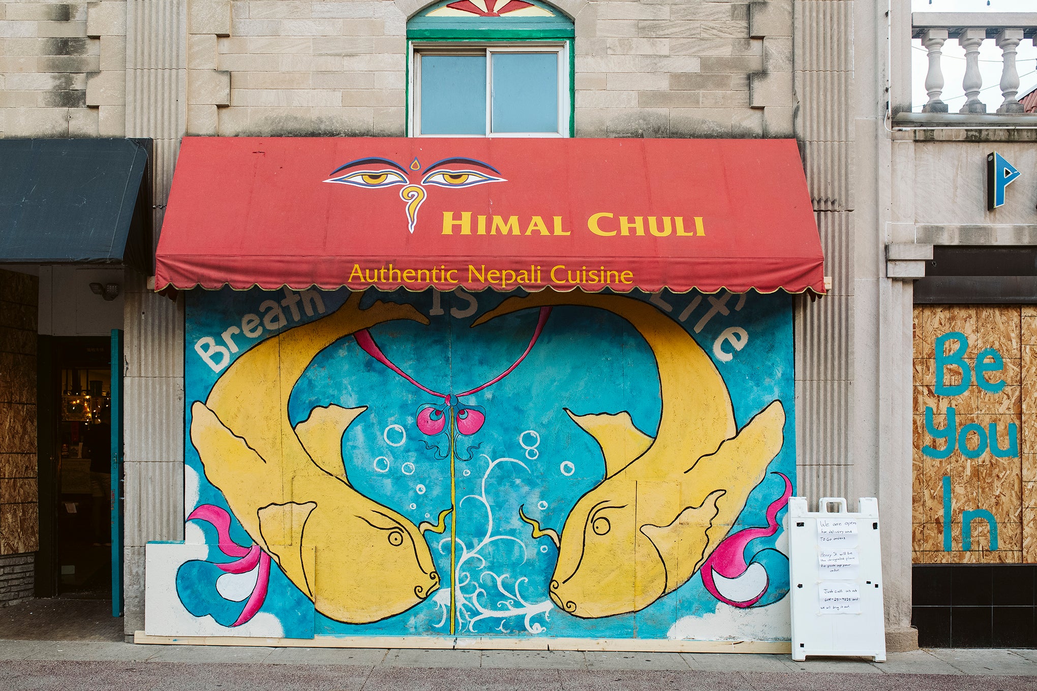 Artwork is displayed on boarded up store windows on State Street in downtown Madison